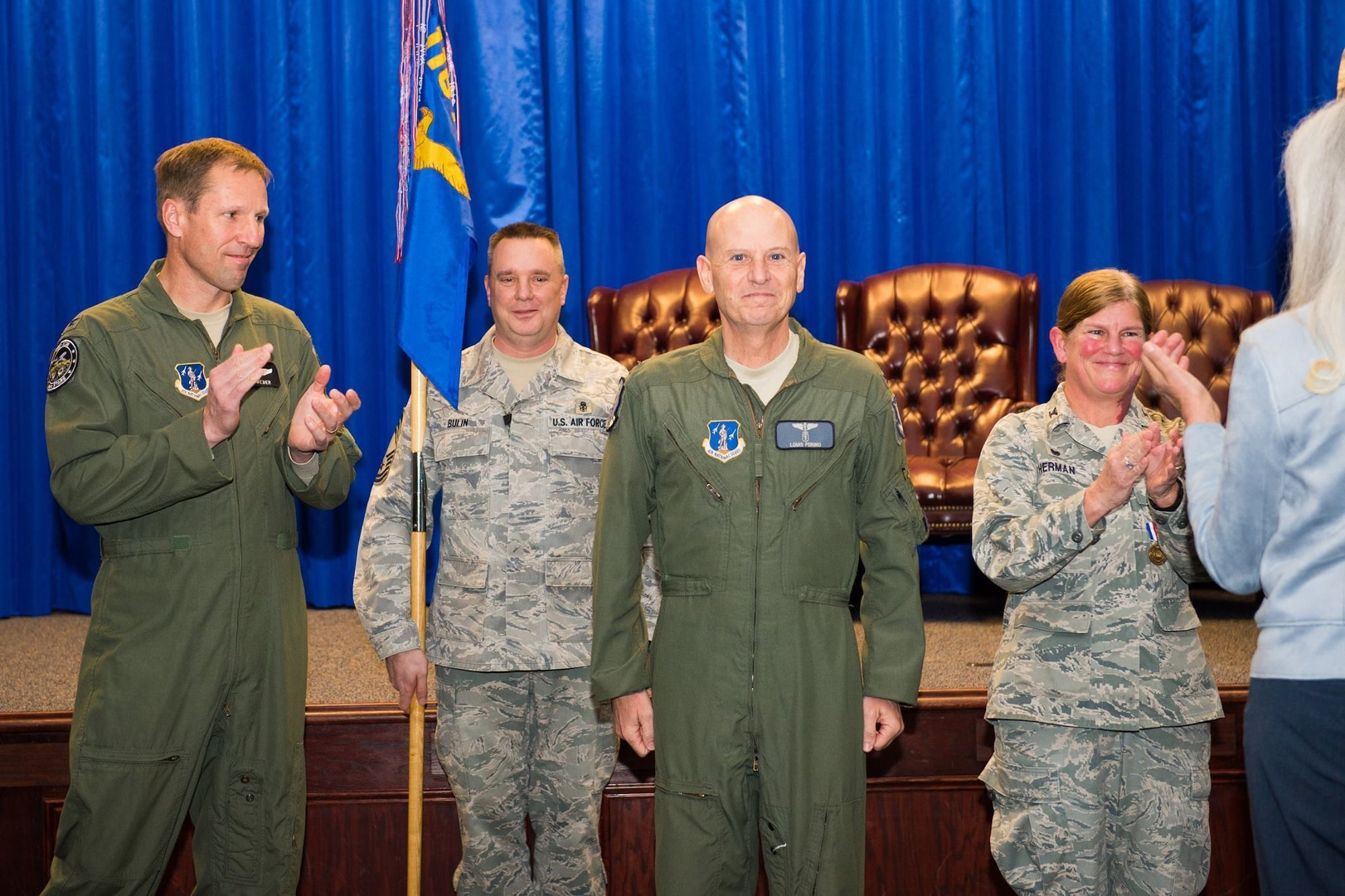 U.S. Air Force Col. Louis Perino, center, the commander of the 116th Medical Group, Georgia Air National Guard, stands at attention while Col. Mark Weber, the commander of the 116th Air Control Wing, left and Col. Muriel Herman, former commander of the 116th Medical Group, applaud after Perino took command of the 116th Medical Group during a ceremony at Robins Air Force Base, Ga., Jan. 10, 2016. A board certified emergency medicine physician, Perino replaced Herman who commanded the group for more than six years. Perino is also the Chief of Aerospace Medicine and the Deputy State Air Surgeon for the Georgia Air National Guard and brings 23 years of Air National Guard and a wealth of civilian experience to the position. (U.S. Air National Guard photo by Senior Master Sgt. Roger Parsons)