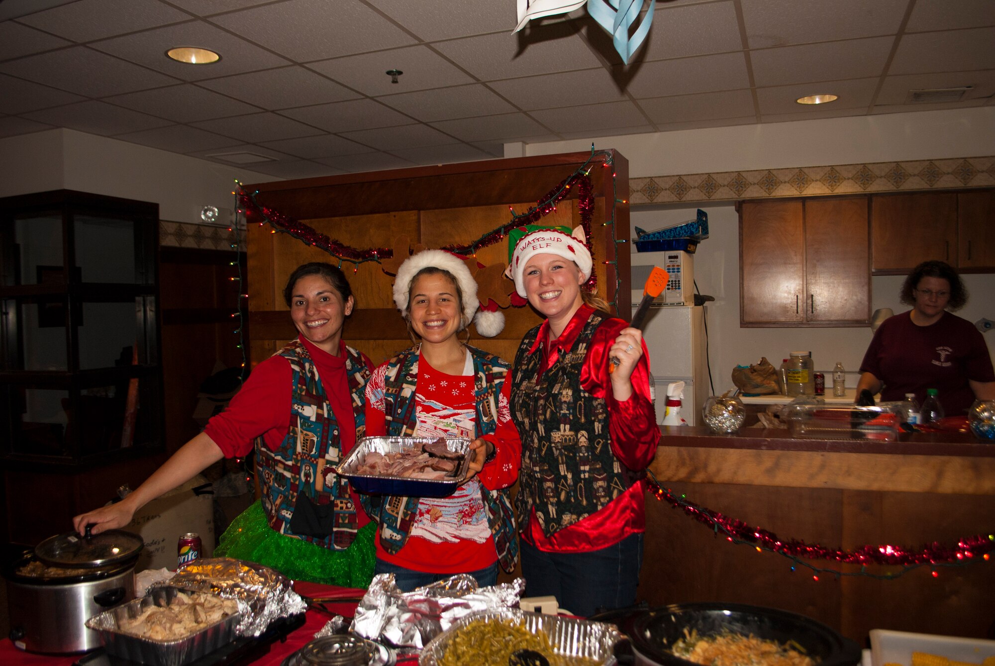 First Lt. Indira Infante, 436th Medical Support Squadron Resource Management Flight commander, left, 2nd Lt. Leah Bratt, 436th MDSS and CGOC social officer, middle, and 2nd Lt. McCall Sears, Community Service Officer for the CGOC, served holiday meals to Airmen living in the dorms Dec. 17, 2015, at Dover Air Force Base, Del. All three officers lead the coordination of the event that fed more than 180 Airmen. (Courtesy photo)