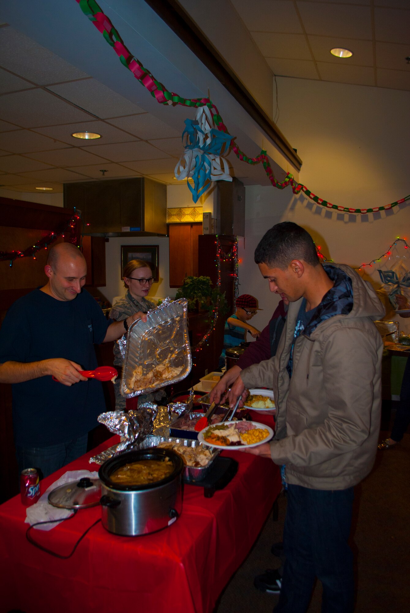 Capt. Christopher Goertz, 436th Security Forces Squadron operations officer, serves an Airmen a home cooked holiday meal Dec. 17, 2015, at Dover Air Force Base Del. The Company Grade Officer’s Council, with help from both the Top III and Chief’s Group, served more than 180 Airmen living in the dorms a holiday meal. (Courtesy photo)