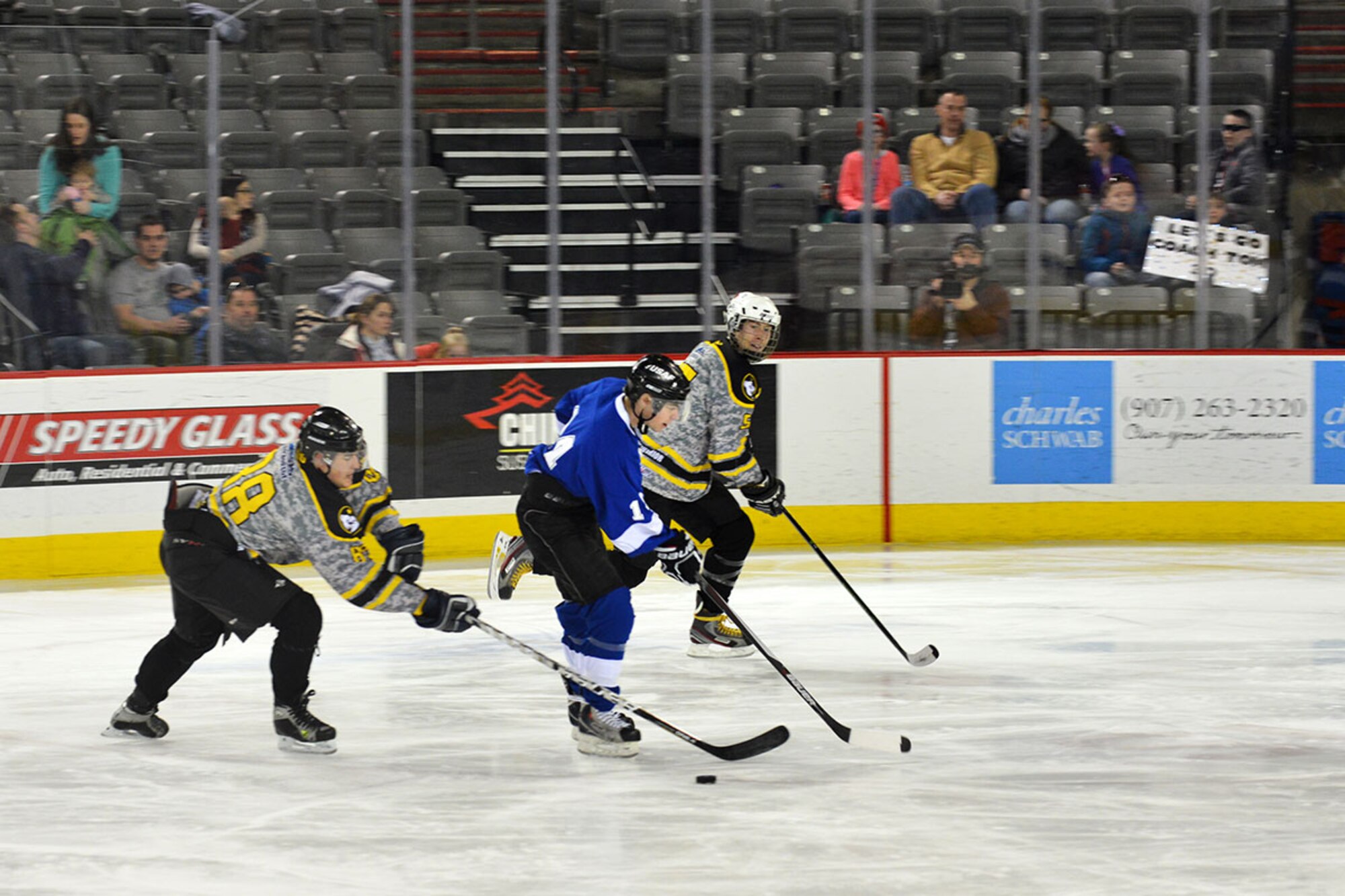 A Joint Base Elmendorf-Richardson, Alaska U.S. Army hockey player steals the puck from an Air Force hockey player at the Sullivan Arena Jan 9 in JBER's Army, Air Force hockey match. The Army came back from a 4-1 point deficit to win the game in a shoot-out and a final score of 7-6. (Air Force photo by Airman 1st Class Kyle Johnson/Released)