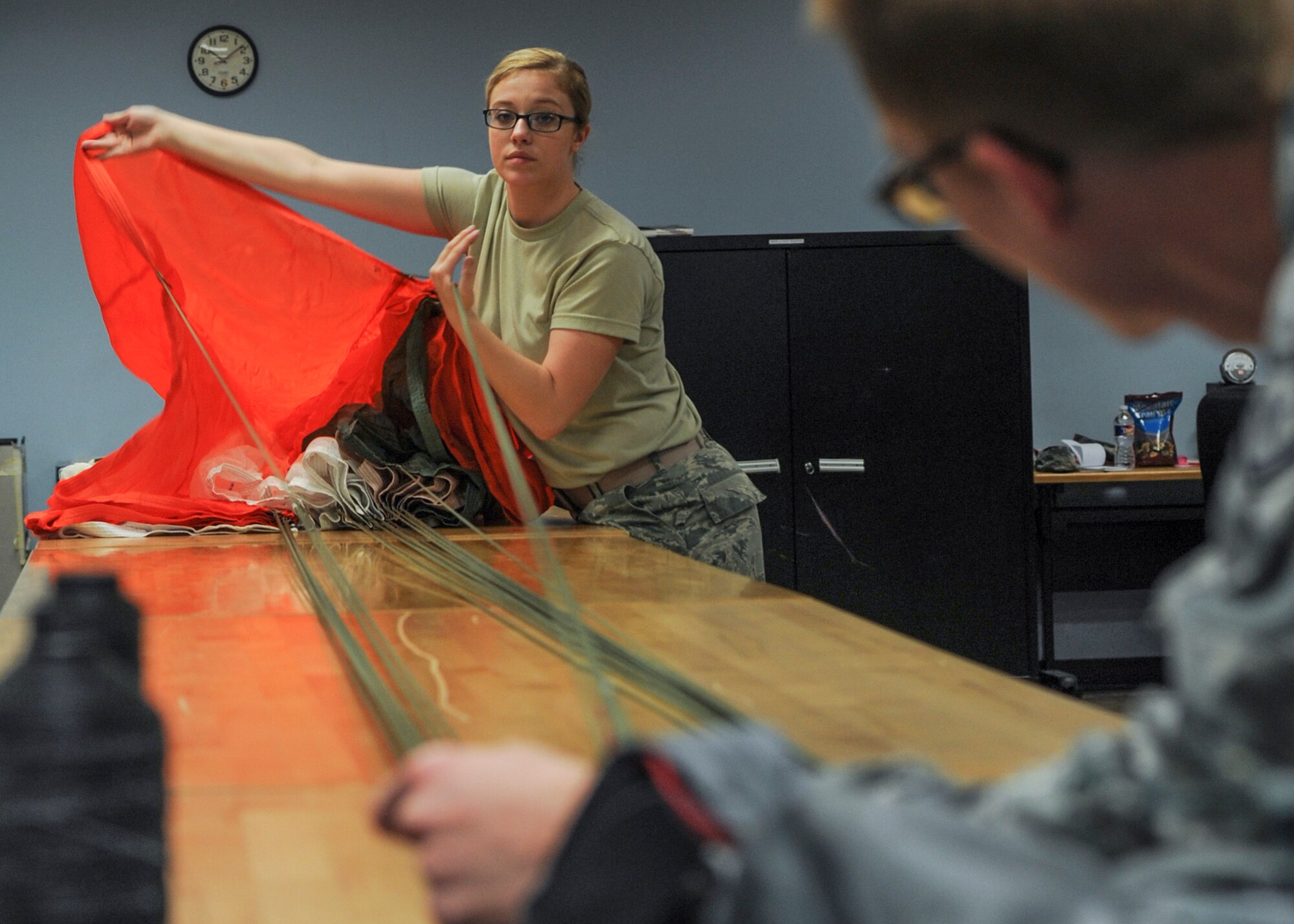 U.S. Air Force Senior Airman Samantha Barlond, 19th Operations Support Squadron aircrew flight equipment journeyman, performs a functional check on a troop parachute Jan. 11, 2016 at Little Rock Air Force Base, Ark. Along with parachutes, AFE Airmen provide fliers with helmets, oxygen masks, flotation devices, survival kits, night vision goggles as well as eye and respiratory protective equipment. (U.S. Air Force photo/Senior Airman Harry Brexel)