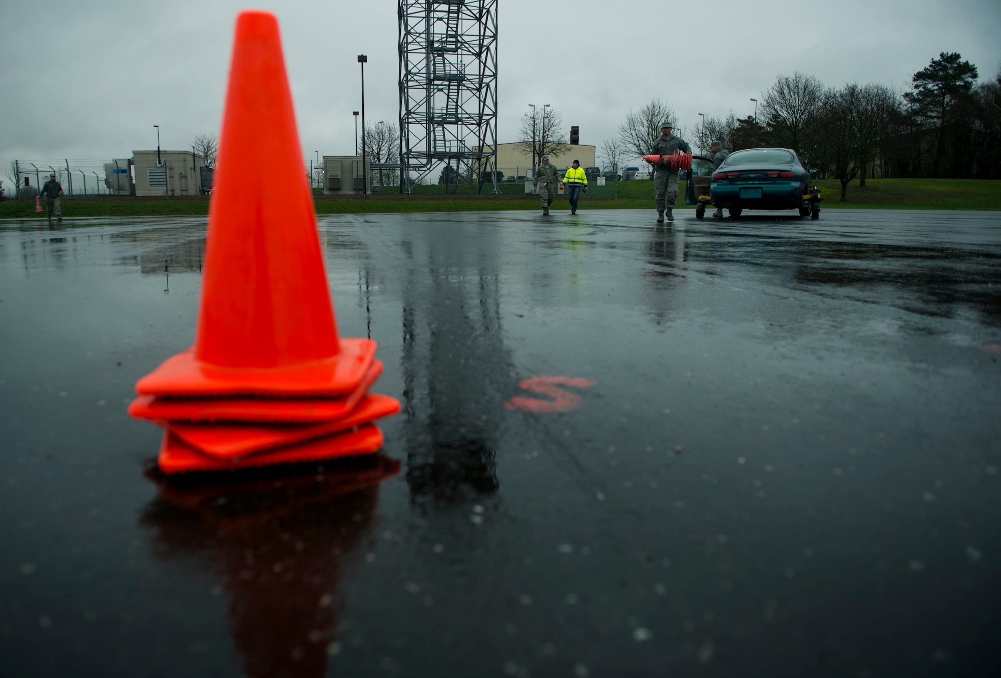 U.S. Air Force Staff Sgt. Brittany McGill, a 52nd Fighter Wing Safety occupational safety and health technician, picks up cones after a training session at the Saber Driving Course at Spangdahlem Air Base, Germany, Jan. 11, 2016. The safety team set up traffic cones around specific markers on the driving course designed for trainees to experience operating a vehicle during specific road conditions. (U.S. Air Force photo by Airman 1st Class Timothy Kim/Released)