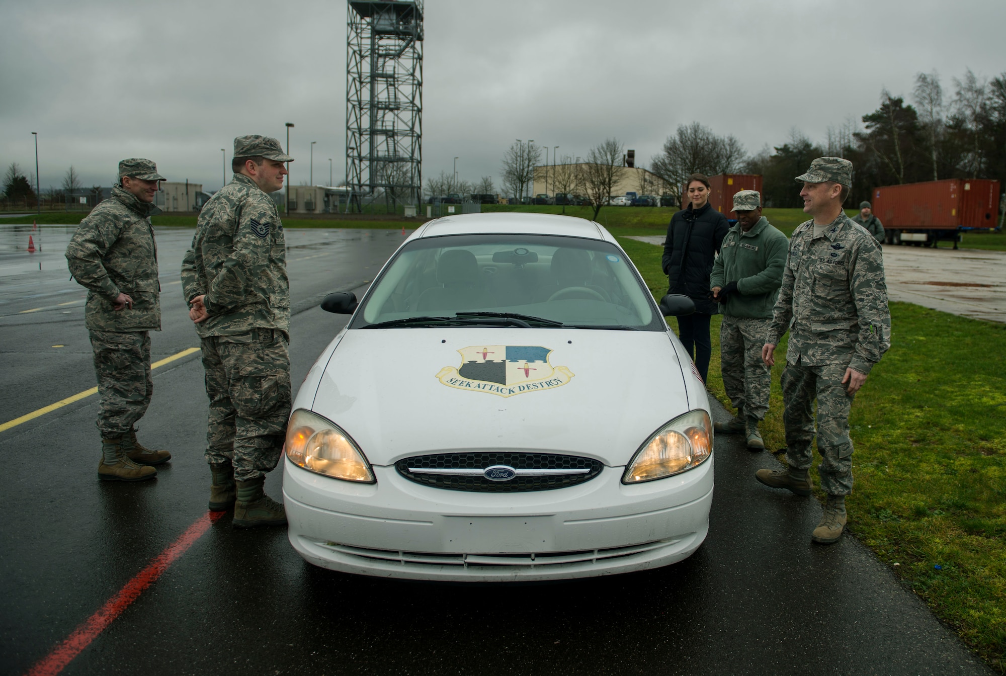 The 52nd Fighter Wing Safety team speaks during a training session at the Saber Driving Course at Spangdahlem Air Base, Germany, Jan. 11, 2016. The vehicle is equipped with special wheel axles that release upon command, simulating a loss of control similar to driving on ice. (U.S. Air Force photo by Airman 1st Class Timothy Kim/Released)