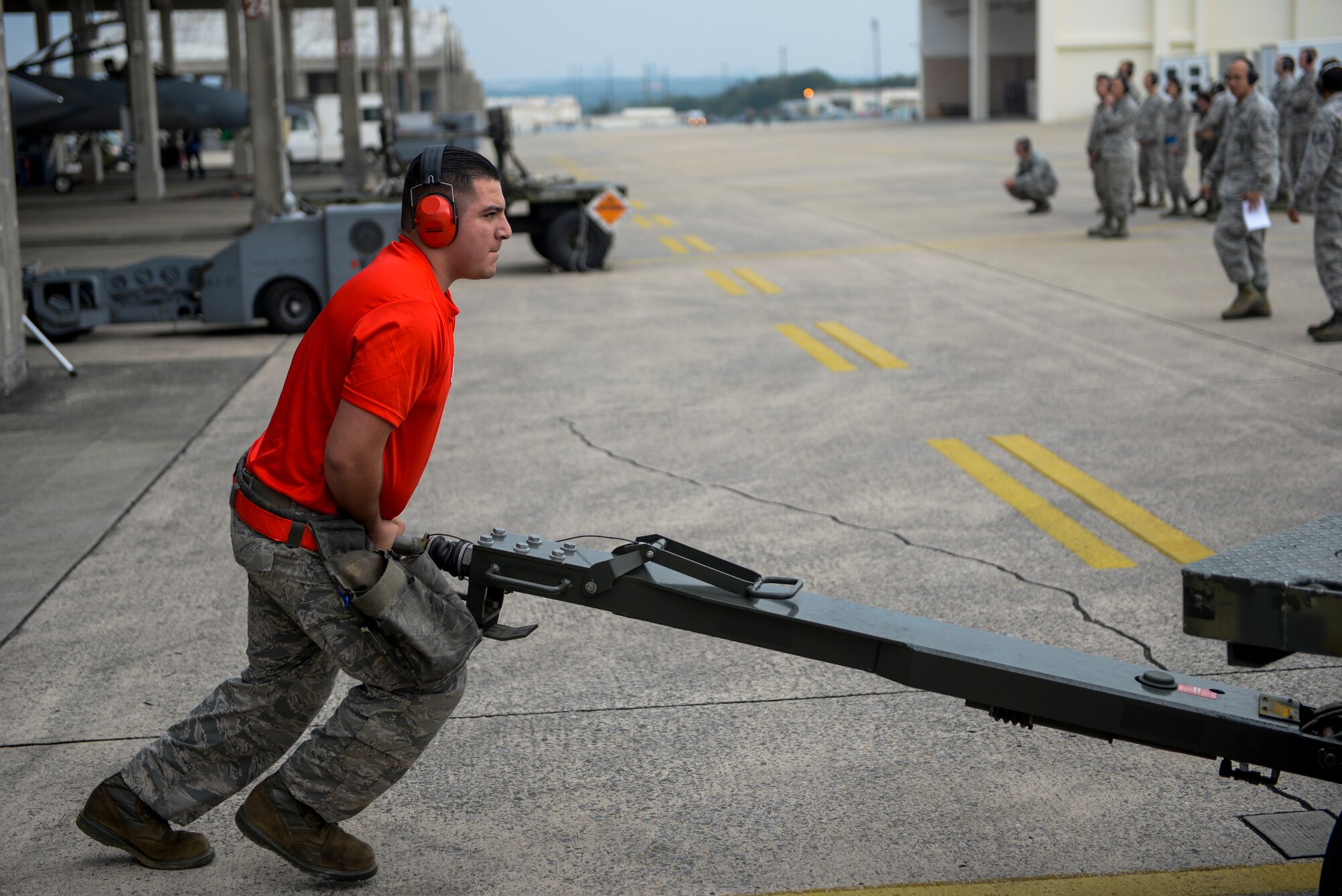 U.S. Air Force Senior Airman Adan Lopez, 67th Fighter Squadron weapons load crew chief, pushes a trailer used to hold munitions during a weapons load competition Jan. 8, 2016, at Kadena Air Base, Japan. The weapons load competition was for the first quarter of 2016 against the 44th Fighter Squadron with the winner gaining bragging rights. (U.S. Air Force photo by Airman Stephen G. Eigel)
