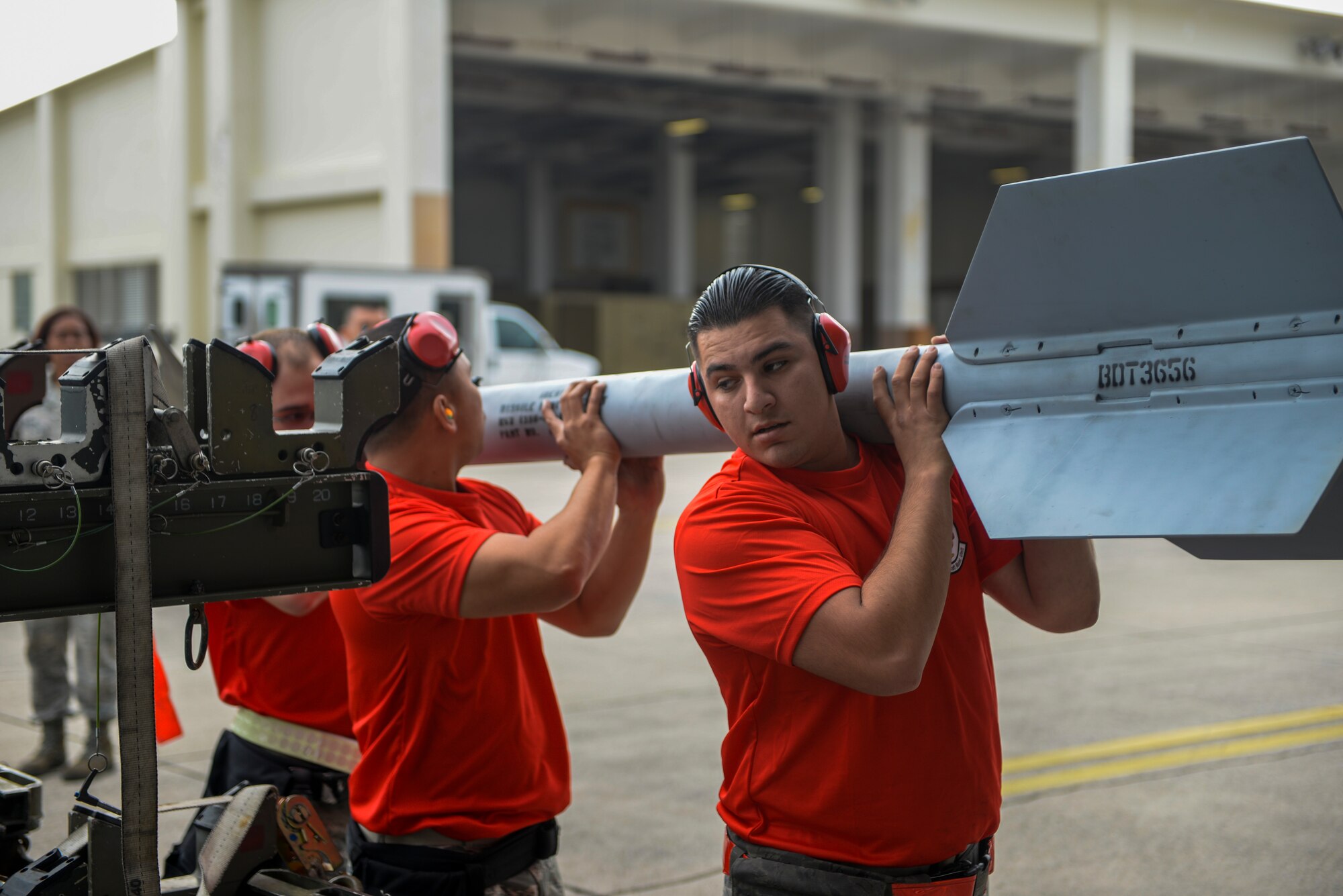 U.S. Air Force Senior Airman Adan Lopez, 67th Fighter Squadron weapons load crew chief, and his team carry an AIM-9L/M Sidewinder missile during a weapons load competition, Jan. 8, 2016, at Kadena Air Base, Japan. Weapons load competitions promote teamwork, readiness and warfighting integration ability. (U.S. Air Force photo by Airman Stephen G. Eigel)
