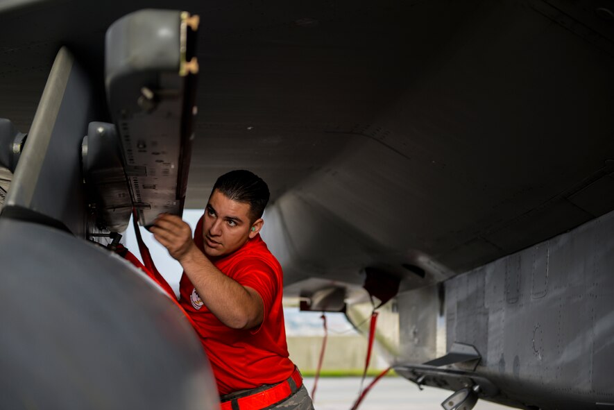 U.S. Air Force Senior Airman Adan Lopez, 67th Fighter Squadron weapons load crew chief, inspects an F-15 Eagle before loading munitions during a weapons load competition Jan. 8, 2016, at Kadena Air Base, Japan. The weapons load competition was for the first quarter of 2016 against the 44th Fighter Squadron with the winner gaining bragging rights. (U.S. Air Force photo by Airman Stephen G. Eigel)

