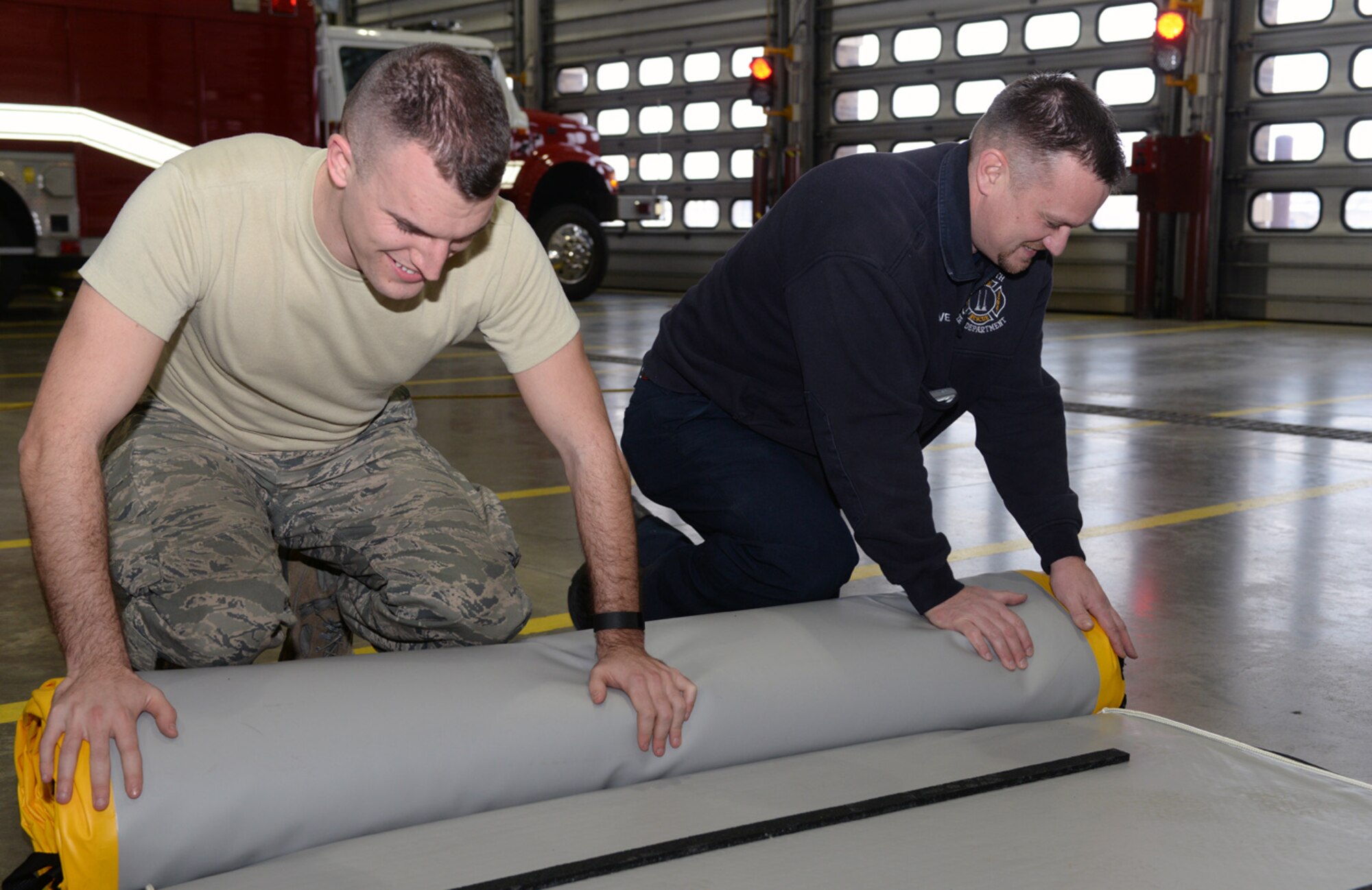 Senior Airman Jordan LaPoint, 28th Civil Engineer Squadron fire protection flight driver operator, left, and Wayne Kolve, 28th CES fire chief, work together to store the supportable water bridge at Ellsworth Air Force Base, S.D., Jan. 7, 2016. The SWB is intended to be used for water and ice rescue missions on unstable grounds. (U.S. Air Force photo by Airman Donald C. Knechtel/Released)