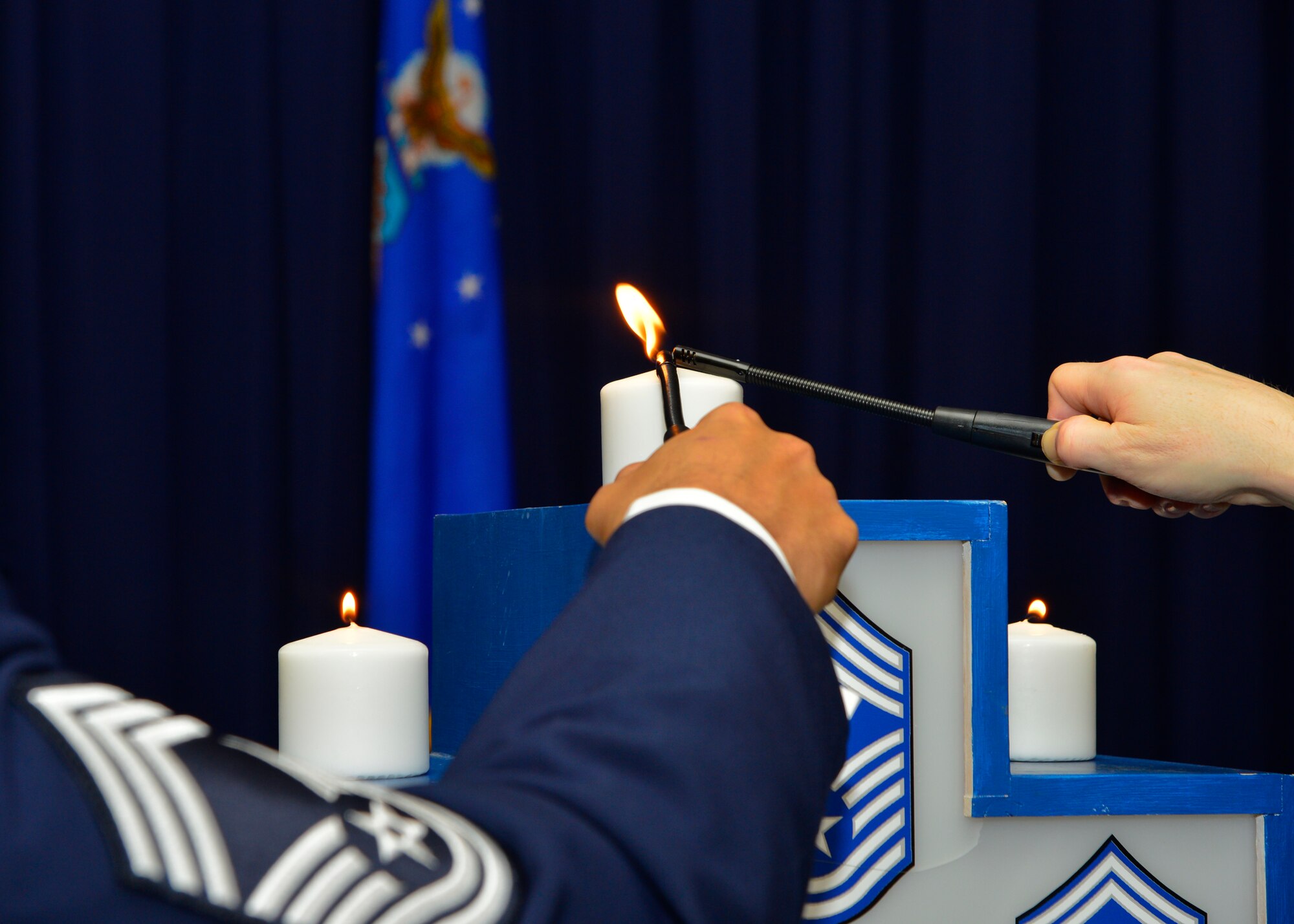 Chief Master Sgt. Geraldo Moore, 436th Airlift Wing interim command chief, and Chief Master Sgt. Brad Ferguson, 512th AW command chief, light a candle representing the rank of chief master sergeant during the Dover Chief Induction Ceremony Jan. 9, 2016, at the Landings on Dover Air Force Base, Del. A candle was lit to represent each rank of the enlisted force. (U.S. Air Force photo/Senior Airman William Johnson)