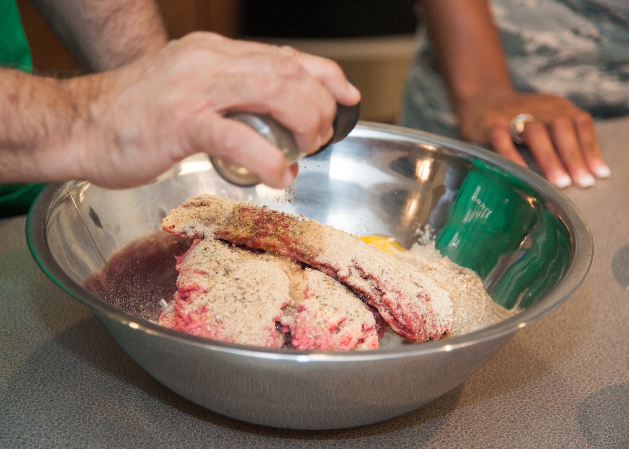 Seasoning is added to a meatball mix during Dorm to Gourm Jan. 5, 2016, at the Health Promotion Flight kitchen in the Fitness Center on Dover Air Force Base, Del. This was the first Dorm to Gourm of 2016 after the winter holiday season. (U.S. Air Force photo/Staff Sgt. Jared Duhon) 