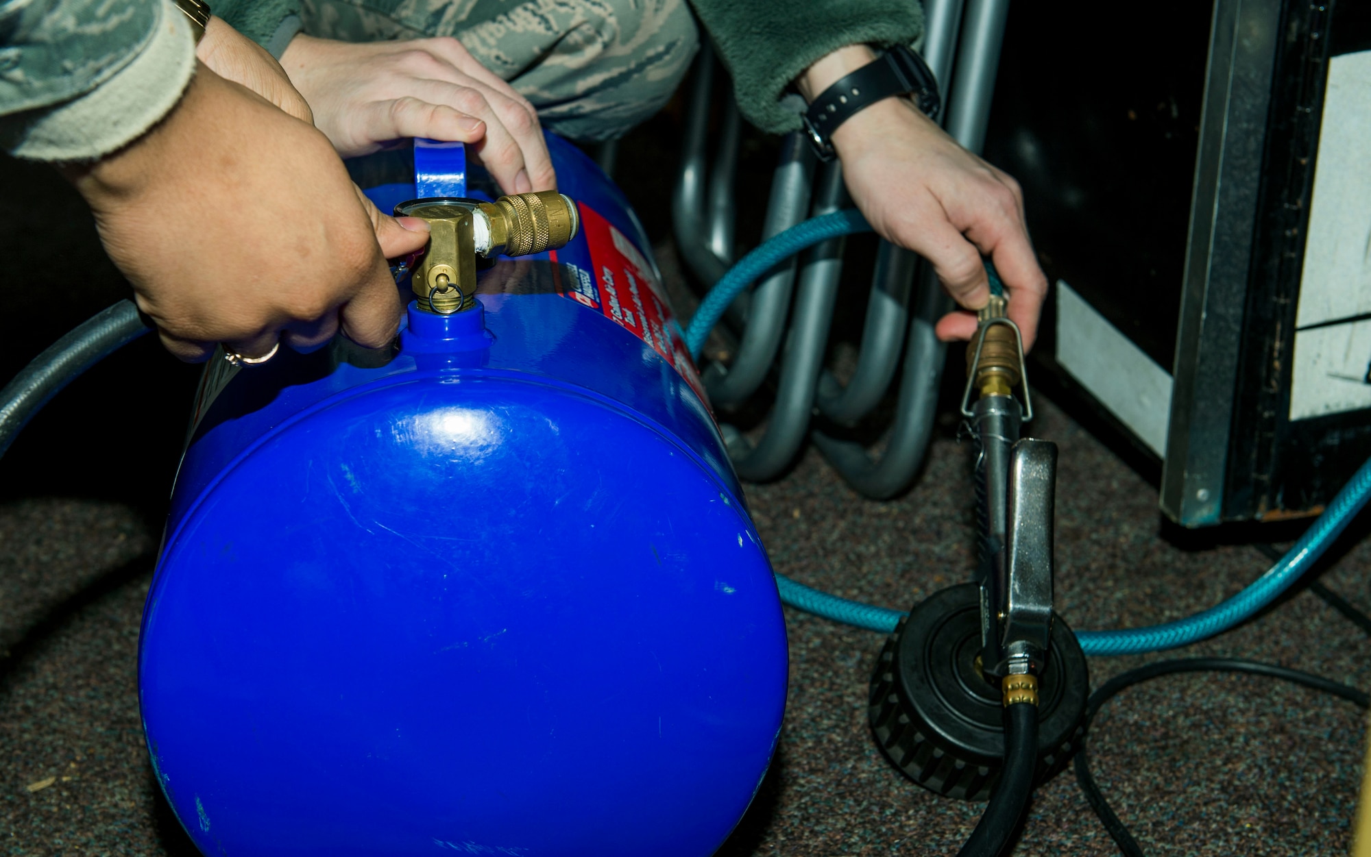 U.S. Air Force Staff Sgt. Brittany McGill, right, and U.S. Air Force Staff Sgt. Jessica Morgan, both 52nd Fighter Wing Safety occupational safety and health technicians, refill a hydraulics tank before a training session at the 52nd FW Safety building at Spangdahlem Air Base, Germany, Jan. 8, 2016. The 52nd FW Safety technicians use the hydraulics system as a tool to release and lock special wheels located on the rear of their training vehicle, simulating slippery road conditions when released. (U.S. Air Force photo by Airman 1st Class Timothy Kim/Released)