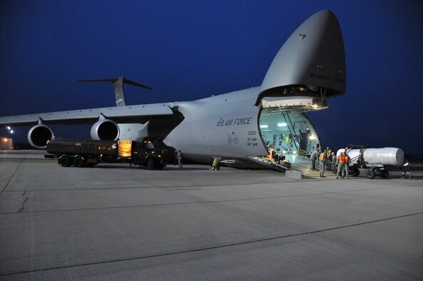 Members of the 114th Logistics Readiness Squadron assist C-5 Galaxy crewmembers load equipment during the early morning hours May 11, 2015 at Joe Foss Field. The South Dakota Air National Guard’s 114th Fighter Wing prepares to deploy almost 250 members on a four month deployment to South Korea where they will support the United States' continual commitment to stability and security in the region. (U.S. Air National Guard photo by Staff Sgt. Luke Olson/Released)