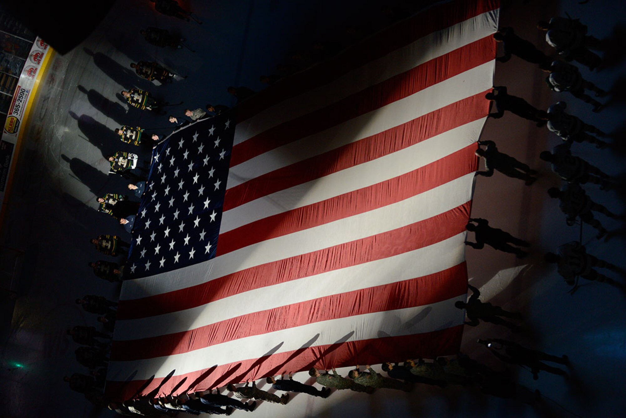 Joint Base Elmendorf-Richardson service members and Alaska Military Youth Academy cadets present the garrison flag during a University of Alaska Anchorage military appreciation hockey game at the Sullivan Arena in Anchorage, Alaska, Jan. 9, 2016. The UAA coordinated the military appreciation game to coincide with the annual Army vs. Air Force hockey game. (U.S. Air Force photo by Airman Valerie Monroy)