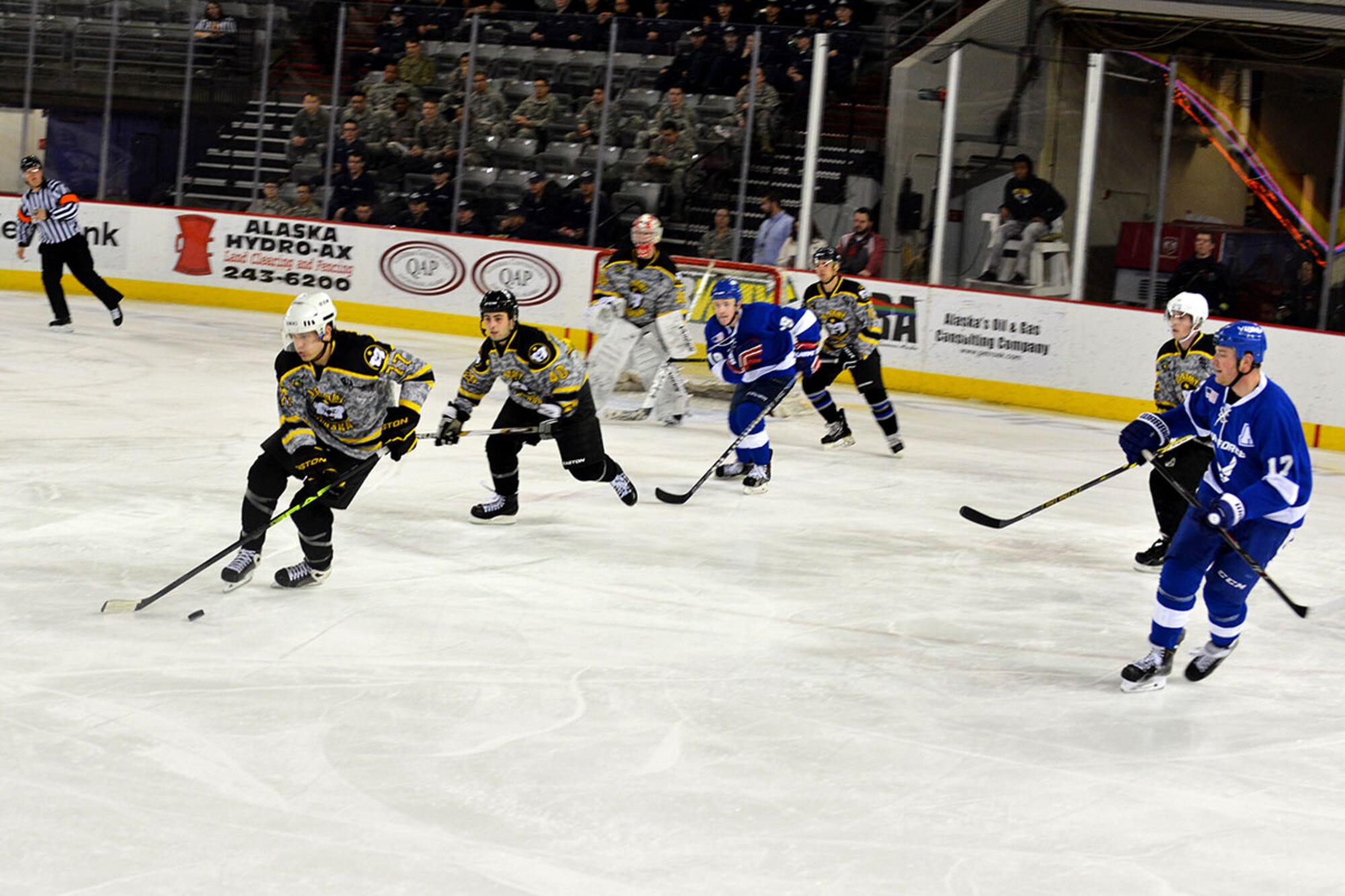 A Joint Base Elmendorf-Richardson, Alaska U.S. Army hockey player takes the puck down the ice toward the Air Force side in JBER's Air Force vs. Army hockey match at the Sullivan Arena Jan 9. The Army came back from a 4-1 point deficit to win the game in a shoot-out and a final score of 7-6. (Air Force photo by Airman 1st Class Kyle Johnson/Released)