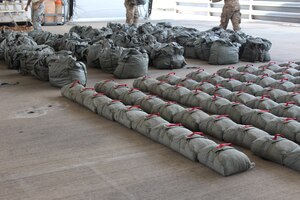 Service members with the Special Operations Command South (Forward) 7310 arrange parachutes after a static-line training exercise involving U.S. and Honduran soldiers on Soto Cano Air Base, January 11, 2016. Training events such as these enhance partner nation interoperability by providing an opportunity for the SOC FWD and the 2nd Honduran Airborne Brigade to exchange knowledge and experiences. (U.S. Army photo by Maria Pinel)