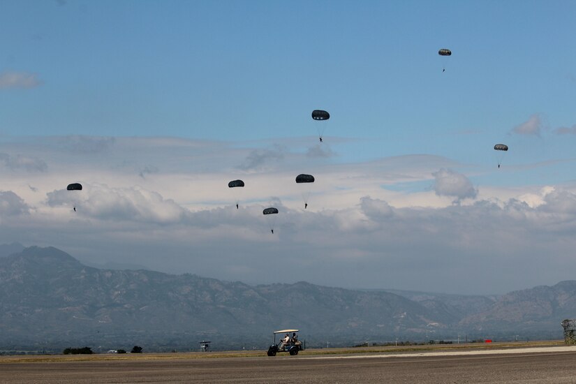 U.S. Army Soldiers with the Special Operations Command South (Forward) 7310 and Honduran soldiers with the 2nd Honduran Airborne Brigade descend over the flight line at Soto Cano Air Base during a static-line training exercise, January 11, 2016. Training events such as these enhance partner nation interoperability and provide an opportunity for SOC FWD and the Hondurans to exchange knowledge and experience. (U.S. Army photo by Maria Pinel)