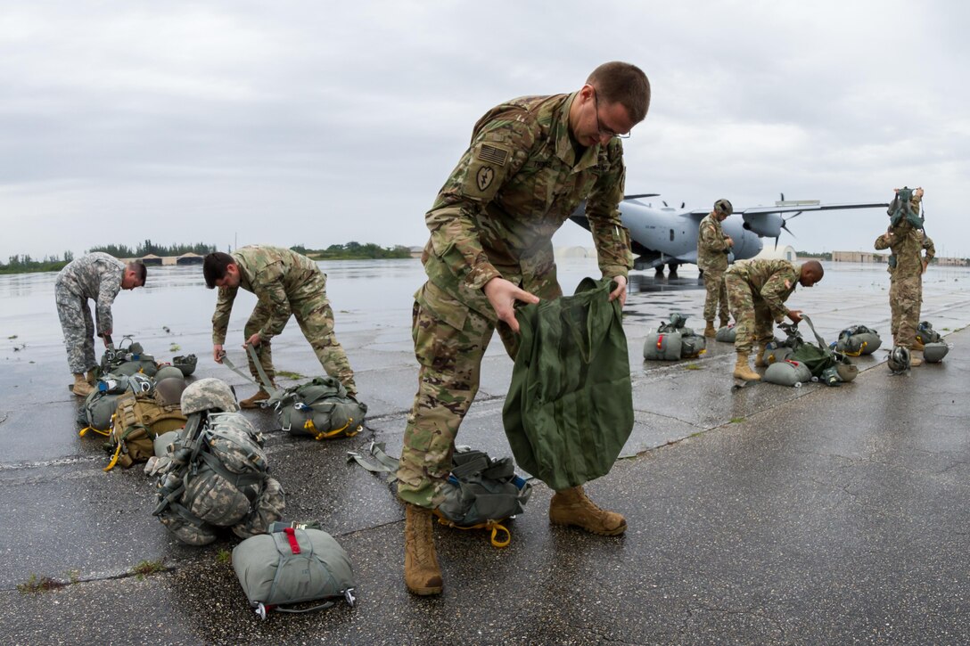 Soldiers prepare their parachutes and equipment before participating in an airborne operation over Homestead Air Reserve Base, Fla., Jan. 12, 2016. The soldiers are assigned to Special Operations Command South. U.S. Army photo by Staff Sgt. Osvaldo Equite