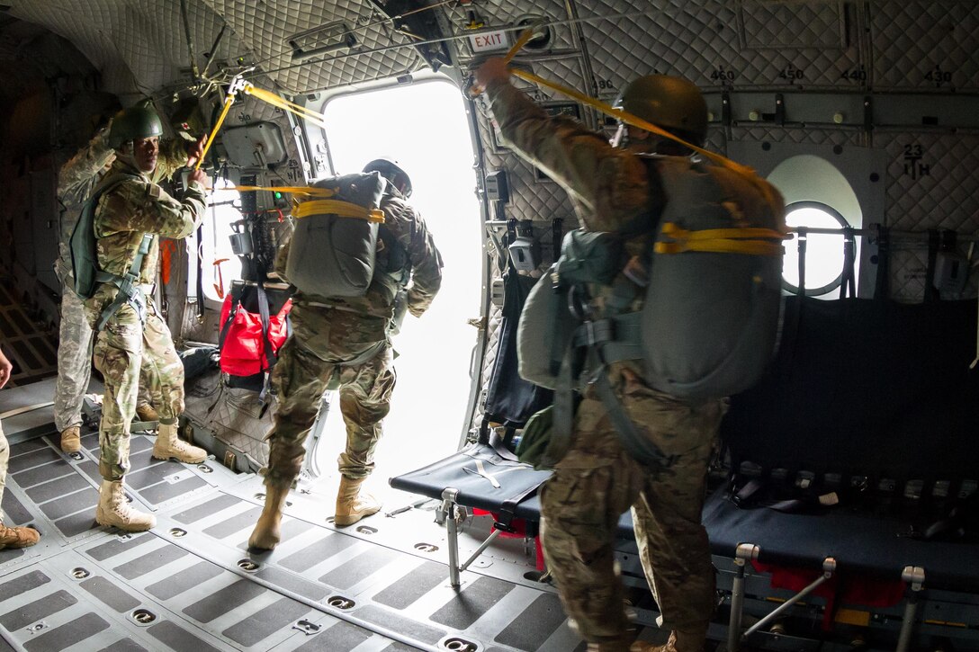 An Army jumpmaster secures a soldier's static line during an airborne operation over Homestead Air Reserve Base, Fla., Jan. 12, 2016. U.S. Army photo by Staff Sgt. Osvaldo Equite