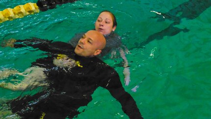 Staff Sgt. Crystal Hopping and Staff Sgt. Carmelo Lopez-Williams, assigned to the U.S. Army Reserve Command, Augmentation Unit (UAU), participate in a buddy-aid exercise during physical fitness and water safety training as part of their battle assembly at Tucker Gym on Jan. 10, 2016, at Fort Bragg, N.C. The mission of the UAU is to augment the USARC staff during exercises, crisis actions, or a presidential selective reserve call-up. Soldiers of the UAU train regularly in order to provide the most qualified, trained, and prepared Soldiers upon request by Army units. (U.S. Army photo by Lt. Col. Kristian Sorensen)