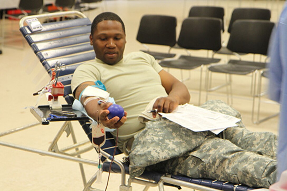 Staff Sgt. Desmond Porter of the 3rd Medical Command Deployment Support squeezes a ball while donating blood to the Armed Services Blood Program to supply much needed blood for those in need around the world. Medical technicians from the Sullivan Memorial Blood Center at Fort Benning, Ga. came to Gillem Enclave to find more donors. U.S. Army photo by Capt. Charles An/released