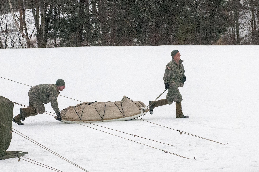 National Guardsmen move the Ahkio sled which contains the tent they'll sleep in at the Camp Ethan Allen Training Site, Jericho, Vt., Jan. 9, 2016. The soldiers are assigned to the Vermont Army National Guard’s Company A, 3rd Battalion, 172nd Infantry Regiment, Mountain. Vermont Army National Guard photo by Sgt. Heidi Kroll