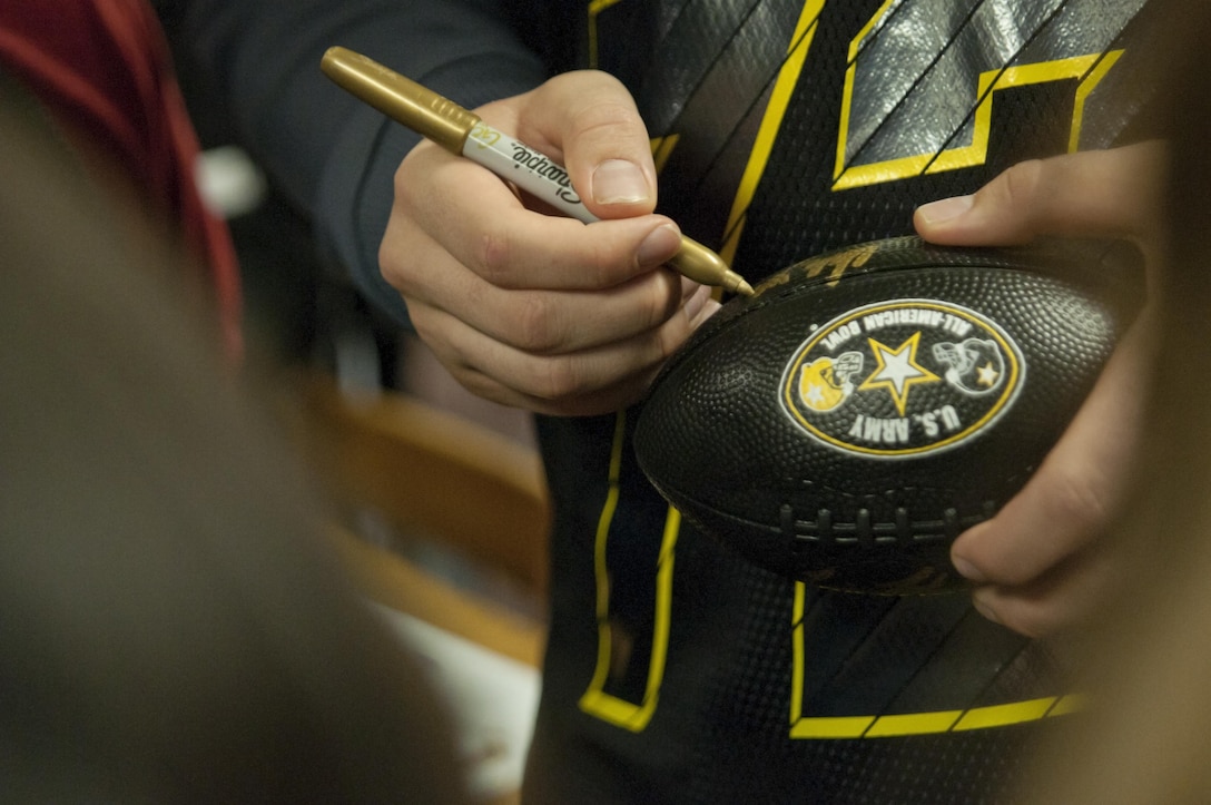 An Army All-American Bowl football player signs an autograph Tuesday, Jan. 5, for a child at Boysville, a program to help youths from abusive and neglectful homes, in San Antonio, Texas. Community outreach has been a key part of the premiere high school game during the 16 years the Army has sponsored the event. (U.S. Army photo by Sgt. Brandon Hubbard, 204th Public Affairs Detachment/Released)