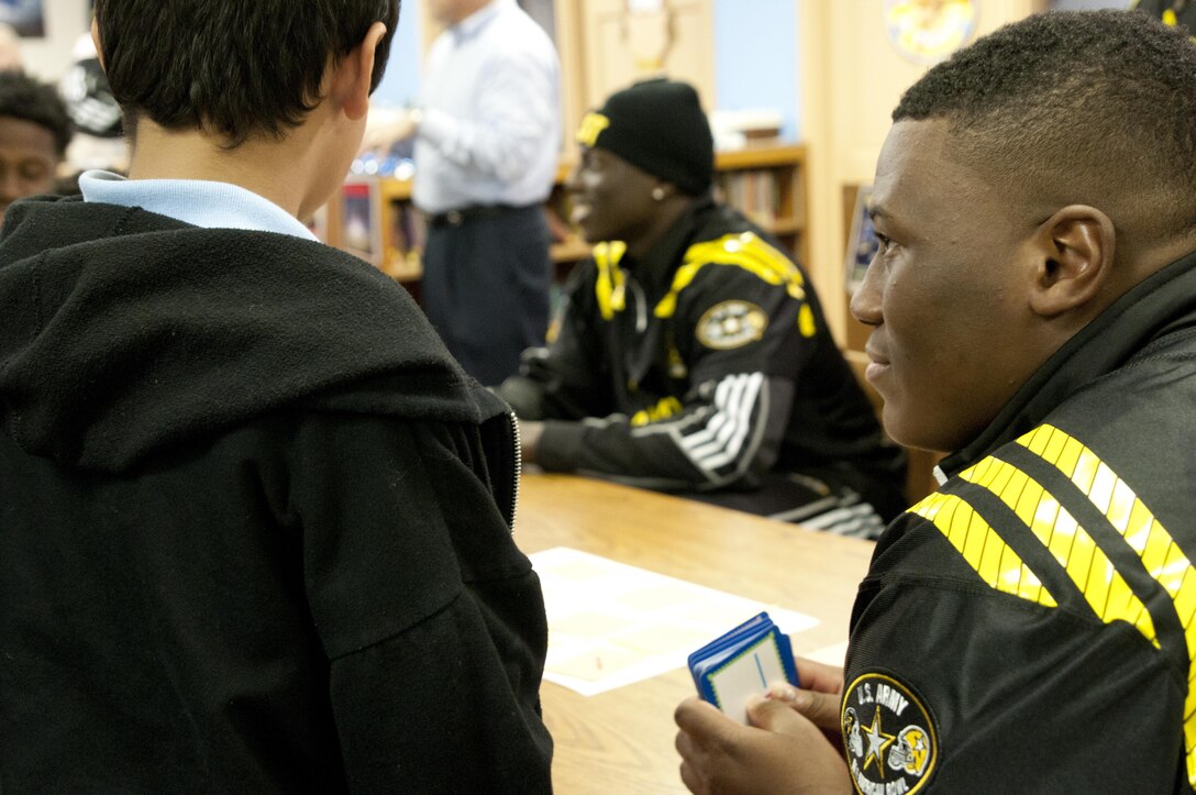 Derrick Brown, a Team East defensive lineman from Lanier High School in Buford, Ga., tries to stump a student on his multiplication skills at Boysville in San Antonio, Texas on Tuesday, Jan. 5, as part of the 2016 Army All-American Bowl. Both Soldiers and the high school football players visited the school in the spirit of the Army’s goal of developing adaptable leaders who can tackle personal challenges, a theme the annual All-American event has tried to embody since the Army became its sponsor in 2002. (U.S. Army photo by Sgt. Brandon Hubbard, 204th Public Affairs Detachment/Released)