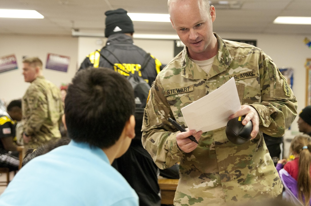 Sgt. 1st Class Ryan Stewart, a Soldier with the U.S. Army Special Operations Command, tests the knowledge of a student Tuesday, Jan. 5 at Boysville in San Antonio, Texas. The Army and top high school football players from around the country visited the children, who are at the school to keep them from abusive and neglectful homes, as part of the 2016 Army All-American Bowl. (U.S. Army photo by Sgt. Brandon Hubbard, 204th Public Affairs Detachment/Released)