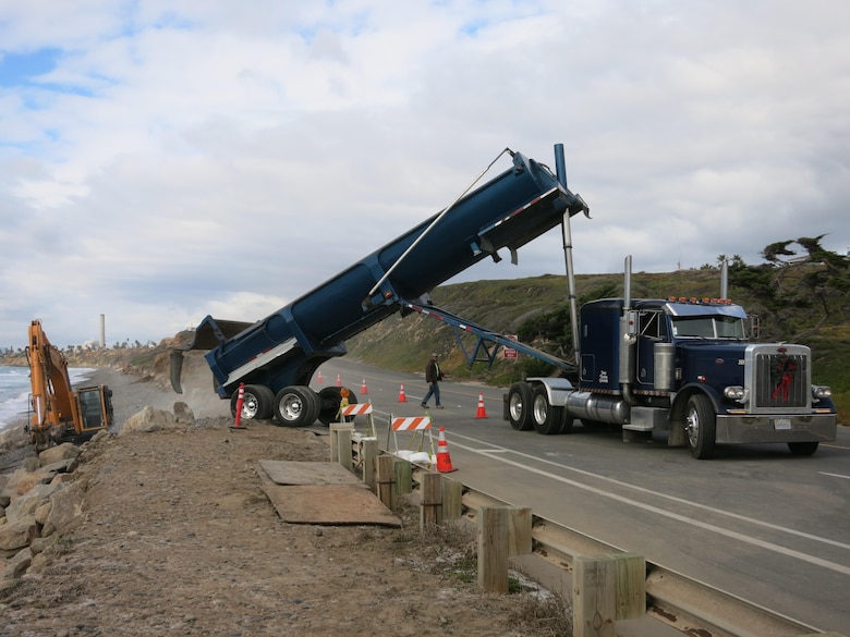 Heavy construction equipment delivers and places rock along a section of the Pacific Coast Highway in Carlsbad. The work is an emergency action authorized by the Corps to protect the coast and adjacent highway.