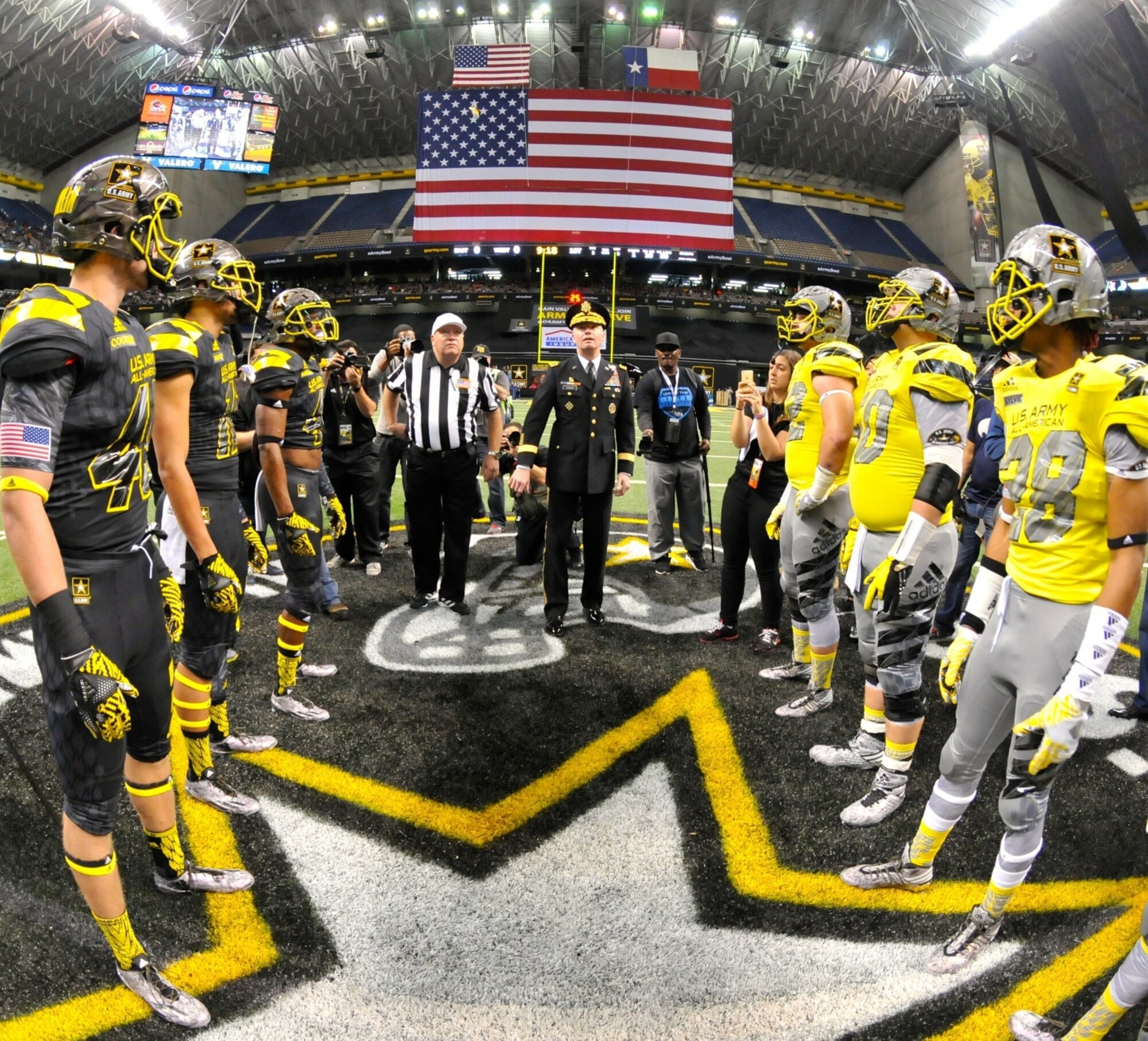 Gen. David G. Perkins, commander of U.S. Army Training and Doctorate Command, flips an Army Challenge Coin to determine which team will receive the option to receive the ball first during the U.S. Army All-American Bowl in San Antonio, Jan. 9, 2016. Perkins visited officials from Air Education and Training Command at Joint Base San Antonio-Randolph, to collaborate with Air Force leaders on advancing education and innovation within the respective military services.