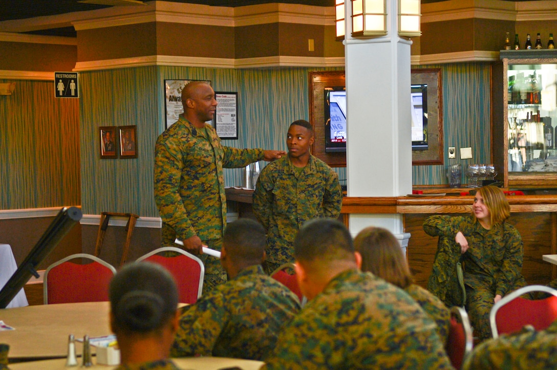 Sgt. Maj. Gerald Saunders gives Lance Cpl. Prince Page, Legal Services Support Section, money to buy tickets to the Masquerade Ball sponsored by Headquarters and Service Battalion. The Marines were gathered for a troop appreciation and professional military education session aboard Marine Corps Base Quantico Jan. 6. 