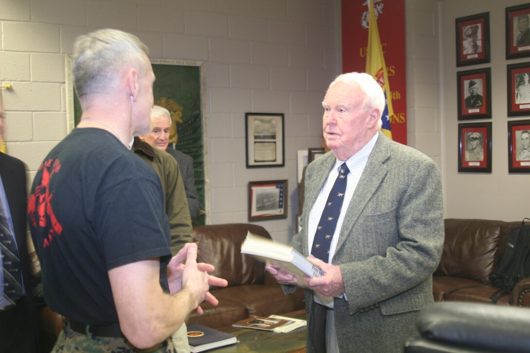 Kemp Norman, a former Marine, presents an original copy of "Bless 'Em All," a comprehensive first-person history of the Marine Raiders written by his stepfather, Oscar Peatross, to Joseph Shusko, director of the Marine Corps Martial Arts Program, which is housed in Raider Hall on The Basic School campus. Peatross was a major general in the Marine Corps who was one of the original Raiders.