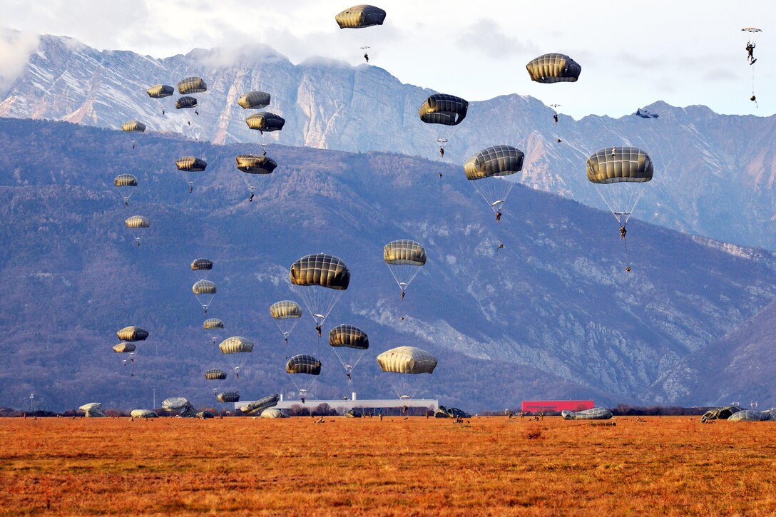 U.S. Army paratroopers descend to the ground after exiting a C-130 Hercules aircraft over the Juliet drop zone in Pordenone, Italy, Jan. 8, 2016. The paratroopers are assigned to the 173rd Brigade Support Battalion. U.S. Army photo by Massimo Bovo