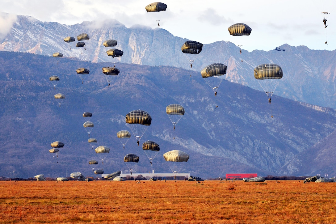 U.S. Army paratroopers descend to the ground after exiting a C-130 Hercules aircraft over the Juliet drop zone in Pordenone, Italy, Jan. 8, 2016. The paratroopers are assigned to the 173rd Brigade Support Battalion. U.S. Army photo by Massimo Bovo