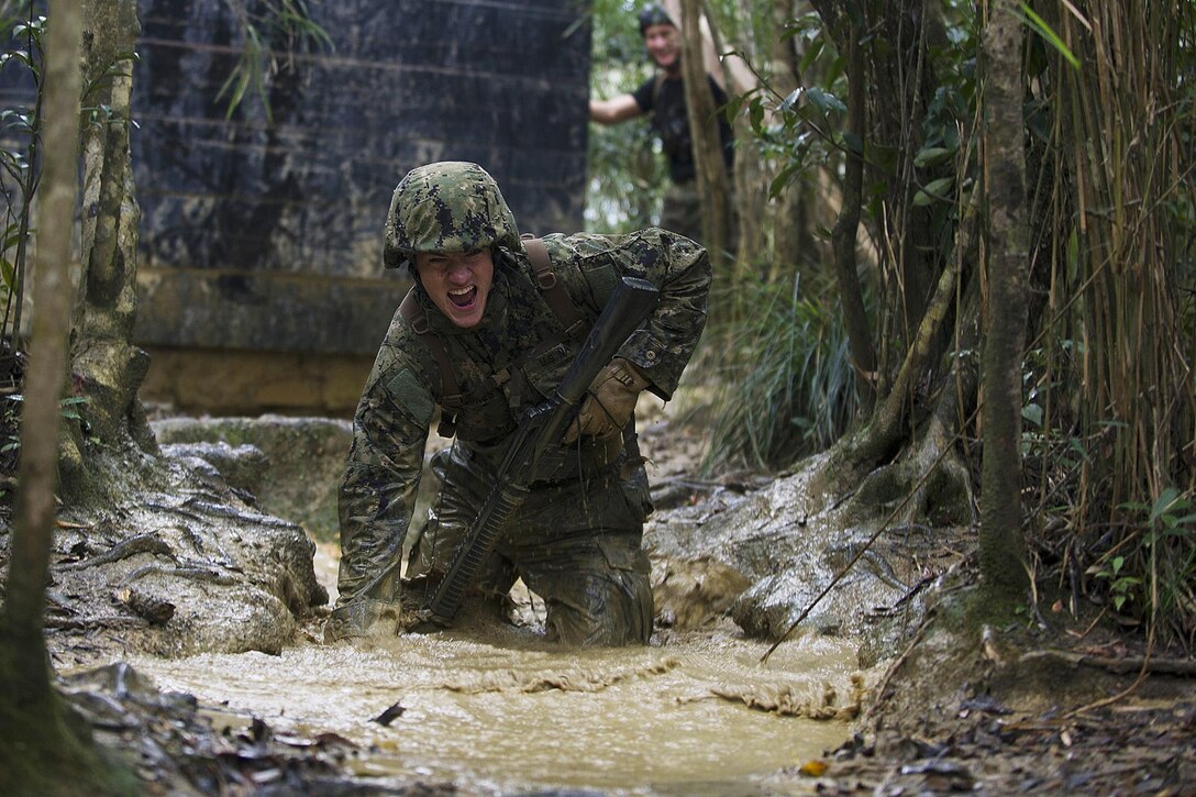 U.S. Navy Seaman Jacob H. Raines moves through knee-high mud and water while running a six-hour endurance course at the Marine Corps Jungle Warfare Training Center in Okinawa, Japan, Jan. 12, 2016. U.S. Navy photo by Petty Officer 1st Class Michael Gomez