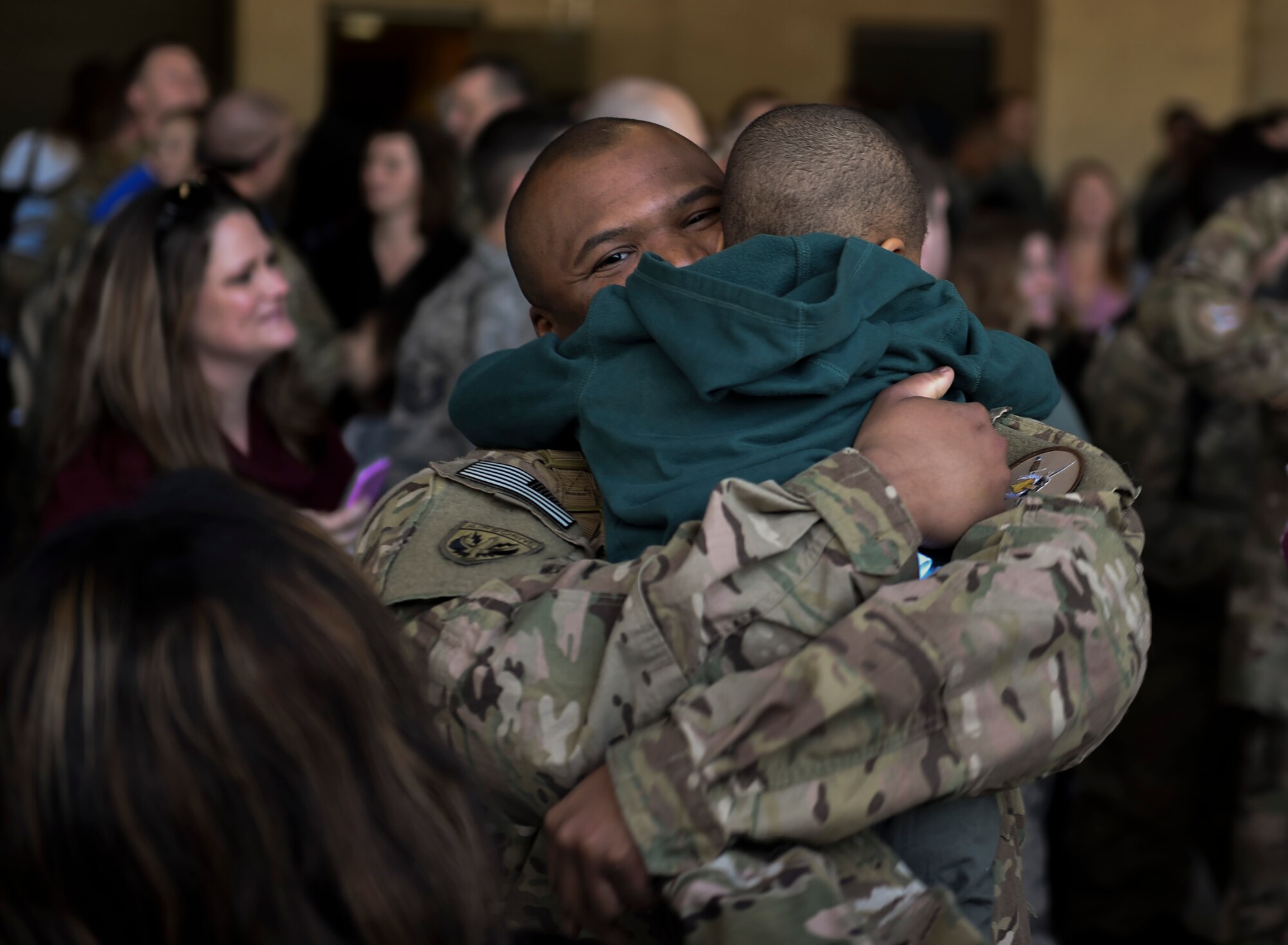 Staff Sgt. Kenneth Redmon, an armament systems craftsman with the 1st Special Operations Aircraft Maintenance Squadron, reunites with his son during an Operation Homecoming at the Deployment Control Center on Hurlburt Field, Fla., Jan 13, 2016. Operation Homecoming brought approximately 80 Airmen home from their deployment overseas.  (U.S. Air Force photo by Senior Airman Ryan Conroy)