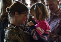 An Air Commando shares a moment with her daughter during an Operation Homecoming at the Deployment Control Center on Hurlburt Field, Fla., Jan. 13, 2016. Operation Homecoming brought approximately 80 Airmen home from their deployment overseas.  (U.S. Air Force photo by Senior Airman Ryan Conroy)
