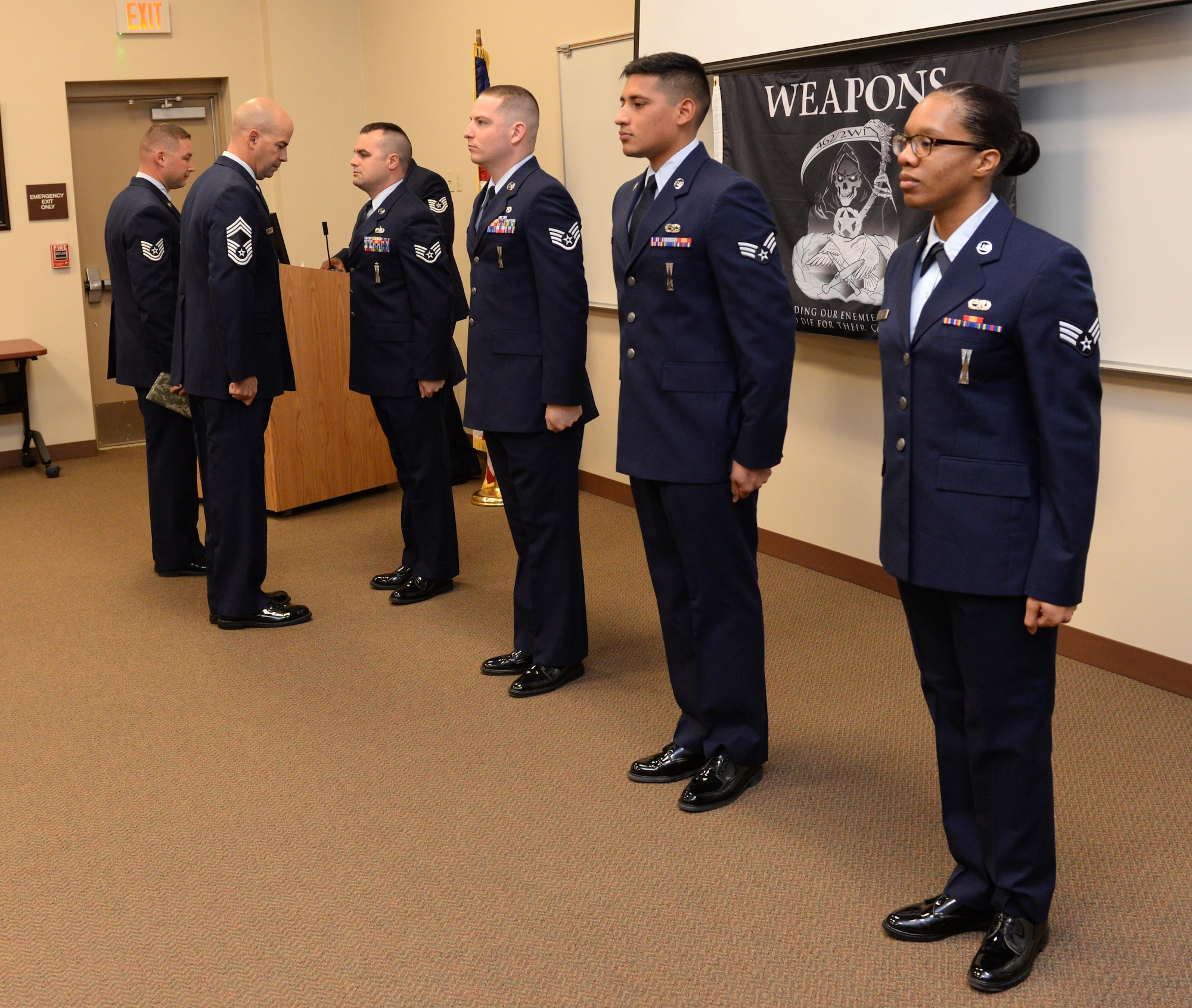 Chief Master Sgt. Brian Huber, 2nd Mission Support Group superintendent, inspects the dress and appearance of Airmen from the 20th Aircraft Maintenance Unit as part of the fourth quarter weapons load competition at Barksdale Air Force Base, La., Jan. 7, 2016. Each quarter the top crew from the 20th AMU squares off against the top crew from the 96th Aircraft Maintenance Unit and are evaluated based on their performances on a written test, dress and appearance inspection, a tool box inspection and weapons load technical operations. (U.S. Air Force photo/Airman 1st Class Curt Beach)