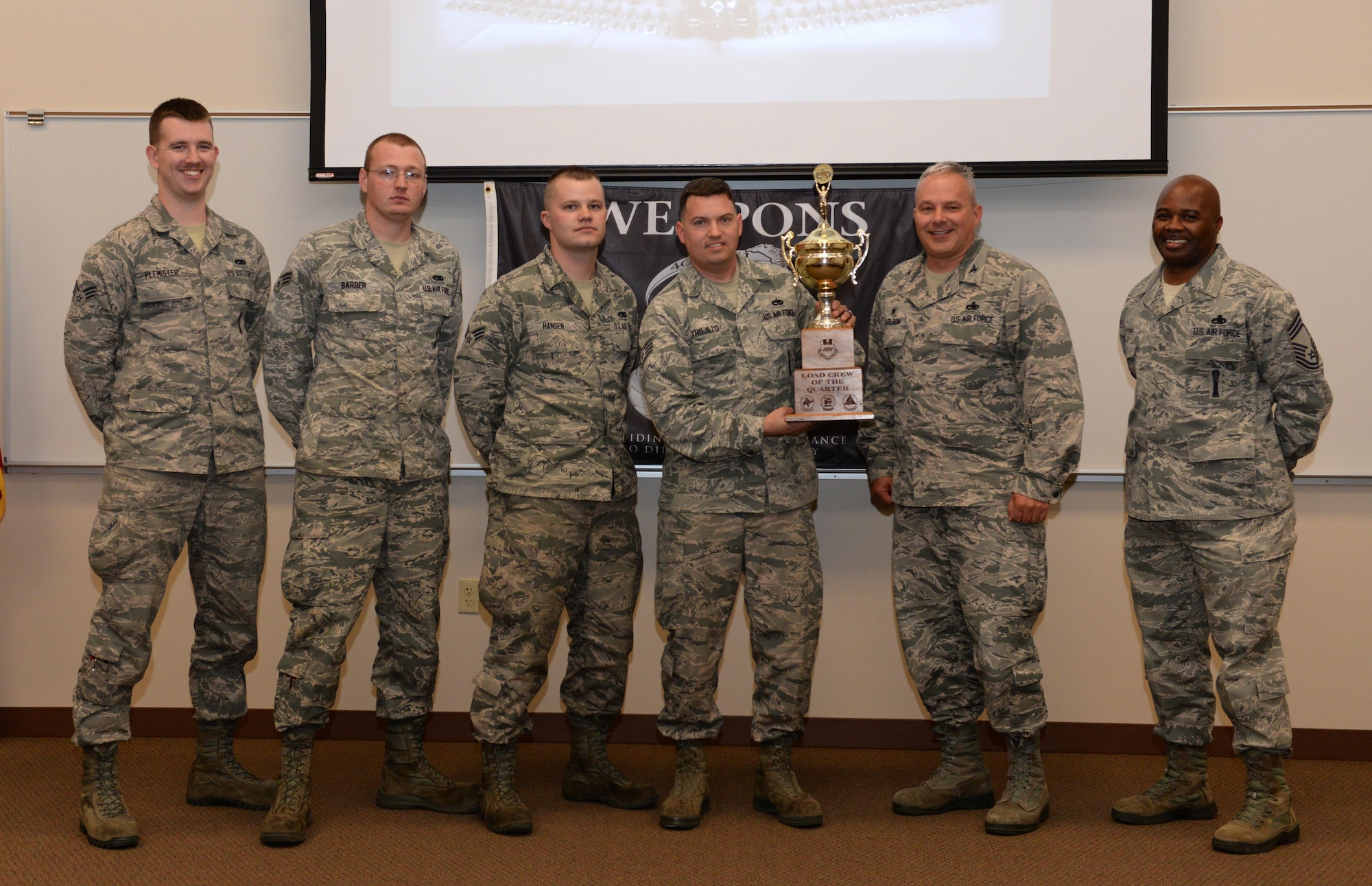 The 96th Aircraft Maintenance Unit’s Cobra 7 load crew poses for a photo with Col. David Carlson, 2nd Maintenance Group commander, and Chief Master Sgt. Kim Castro, 2nd MXG superintendent, after winning the fourth quarter weapons load competition at Barksdale Air Force Base, La., Jan. 7, 2016. Cobra 7 prevailed against the 20th Aircraft Maintenance Unit’s top load team, Viper 3, in the competition which included a written test, dress and appearance inspection, a tool box inspection and a weapons load technical operations. (U.S. Air Force photo/Airman 1st Class Curt Beach)