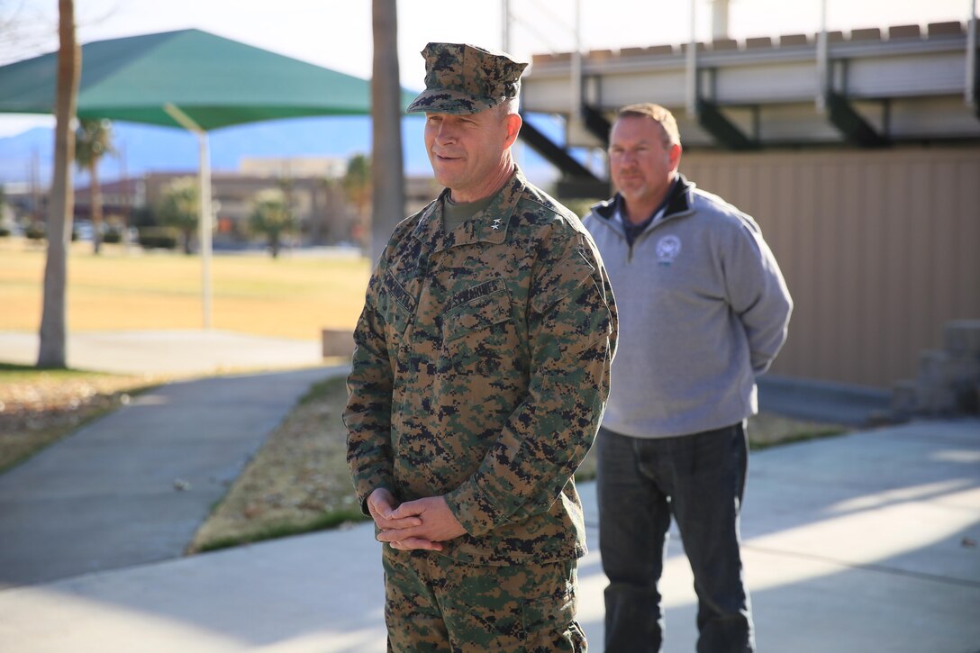 Maj. Gen. Lewis A. Craparotta, Combat Center Commanding General, commends Ronald Genet, former deputy assistant chief of staff, G5, to family members and colleagues during the receipt of Genet’s Meritorious Civilian Service Award at Lance Cpl. Torrey L. Gray Field, Jan. 11, 2016. The Meritorious Civilian Service Award is the third highest award a civilian can receive. (Official Marine Corps photo by Cpl. Julio McGraw/ Released)