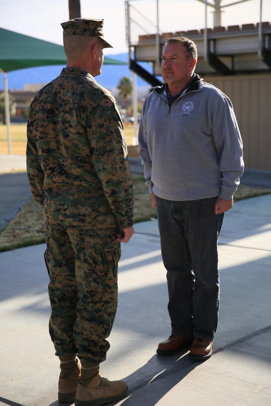 Maj. Gen. Lewis A. Craparotta, Combat Center Commanding General, and Ronald Genet, former deputy assistant chief of staff, G5, stand at the position of attention during the reading of a Meritorious Civilian Service Award citation presented to Genet at Lance Cpl. Torrey L. Gray Field, Jan. 11, 2016. Genet served as the G5, deputy assistant chief of staff for more than six years and now serves as the facilities maintenance officer at the Combat Center’s Public Works Division.  (Official Marine Corps photo by Cpl. Julio McGraw/ Released)