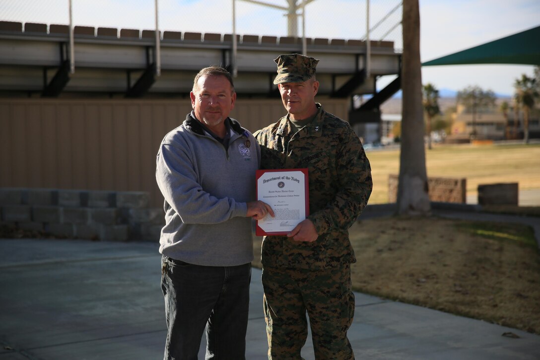 Maj. Gen. Lewis A. Craparotta, Combat Center Commanding General, presents a Meritorious Civilian Service Award to Ronald Genet, former deputy assistant chief of staff, G5, at Lance Cpl. Torrey L. Gray Field, Jan. 11, 2016. (Official Marine Corps photo by Cpl. Julio McGraw/ Released)