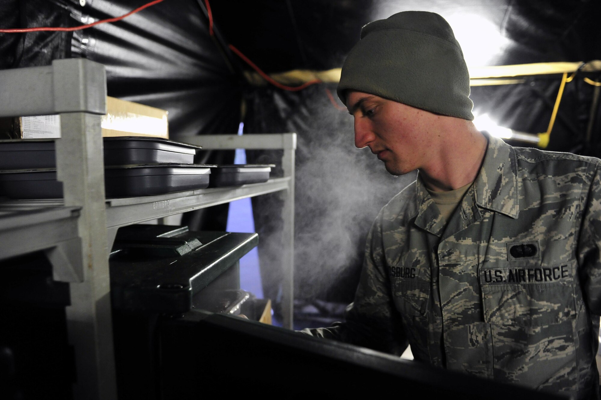 Airman 1st Class Richard Vosburg, fitness specialist with the 1st Special Operations Force Support Squadron, places food into a heated container during exercise Frigid Archer 2016 at Eglin Range, Fla., Jan. 7, 2016. Members of FSS are trained int multiple specialties including fitness, cooking and mortuary affairs. Frigid Archer tested 1st Special Operations Wing Air Commandos’ expertise through a myriad of operational and support requirements. (U.S. Air Force photo by Staff Sgt. Tyler Placie)