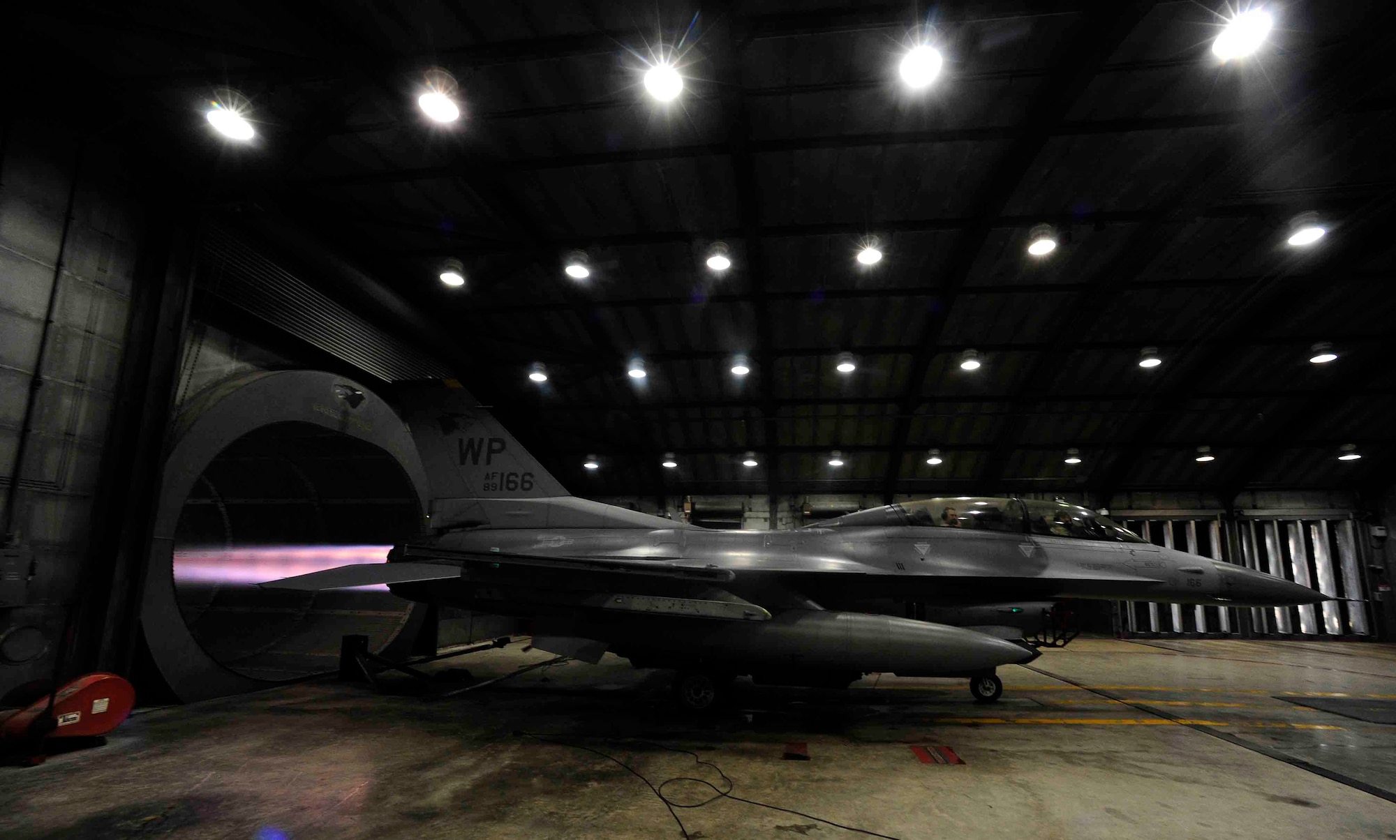 The afterburner of an F-16 Fighting Falcon is run during a hush house engine test at Kunsan Air Base, Republic of Korea, Dec. 9, 2015. The hush house is an engine test facility that is similar to a sound booth in a musical production studio. It keeps all of the sound inside of the facility to prevent any noise from being heard outside.  (U.S. Air Force photo by Staff Sgt. Nick Wilson/Released)