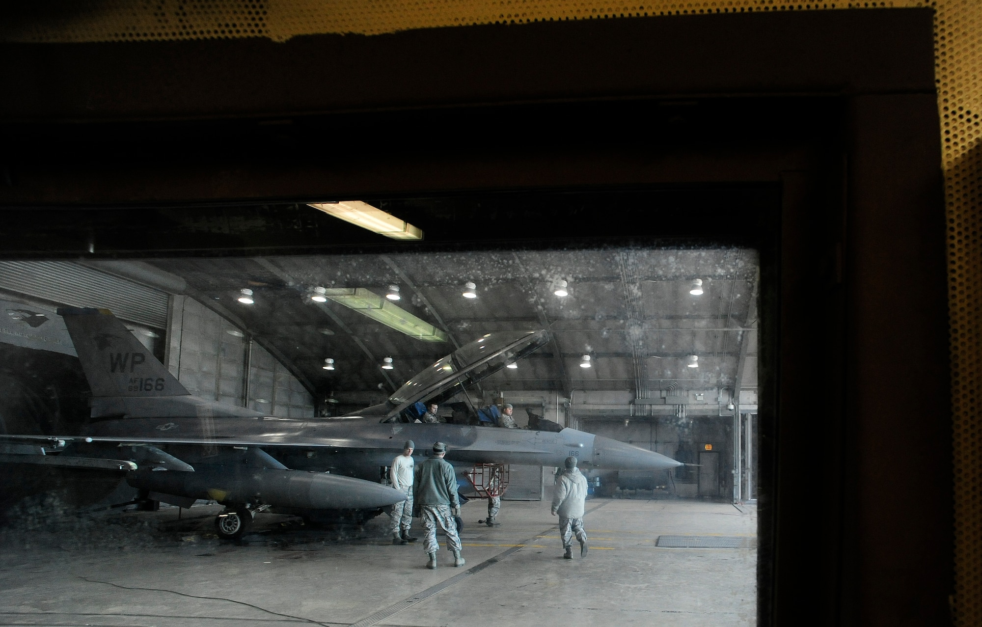 Airmen from the 8th Maintenance Squadron converse with Airmen from the 8th Aircraft Maintenance Squadron after an engine test run in a hush house, at Kunsan Air Base, Republic of Korea, Dec. 9, 2015. In addition to the hush house, the 8th MXS maintenance flight encompasses multiple duty sections, which include a tire shop, aerospace propulsion, crash damage, aircraft recovery and phase.  (U.S. Air Force photo by Staff Sgt. Nick Wilson/Released)