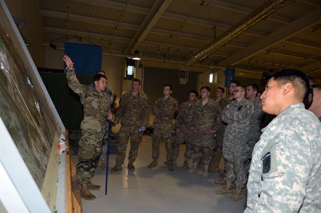 U.S. Army 1st Lt. Ian Macpherson, left, briefs paratroopers on safety at Aviano Air Base, Italy,  before participating in airborne operations on the Juliet drop zone in Pordenone, Italy, Jan. 8, 2016. Macpherson is assigned to the 173rd Brigade Support Battalion. U.S. Army photo by Massimo Bovo 