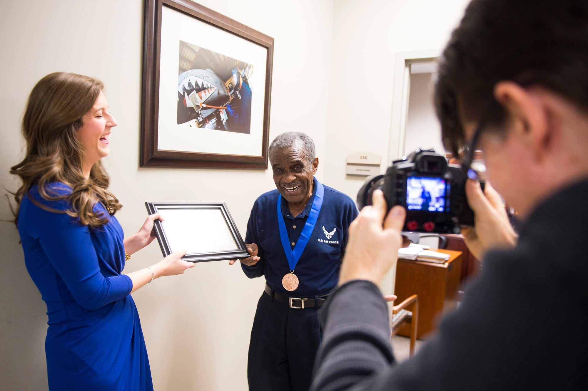 Tracey Smith, a local reporter, shares a laugh with retired U.S. Air Force Chief Master Sgt. James Ingram, 23d Wing retiree activities office director, Jan. 12, 2016, at Moody Air Force Base, Ga. Smith and her camera crew surprised Ingram at work and presented him with the Jefferson Award. The founders created the Jefferson Award in 1972 to establish a Nobel Prize for public service. (U.S. Air Force photo by Senior Airman Ceaira Tinsley/Released)