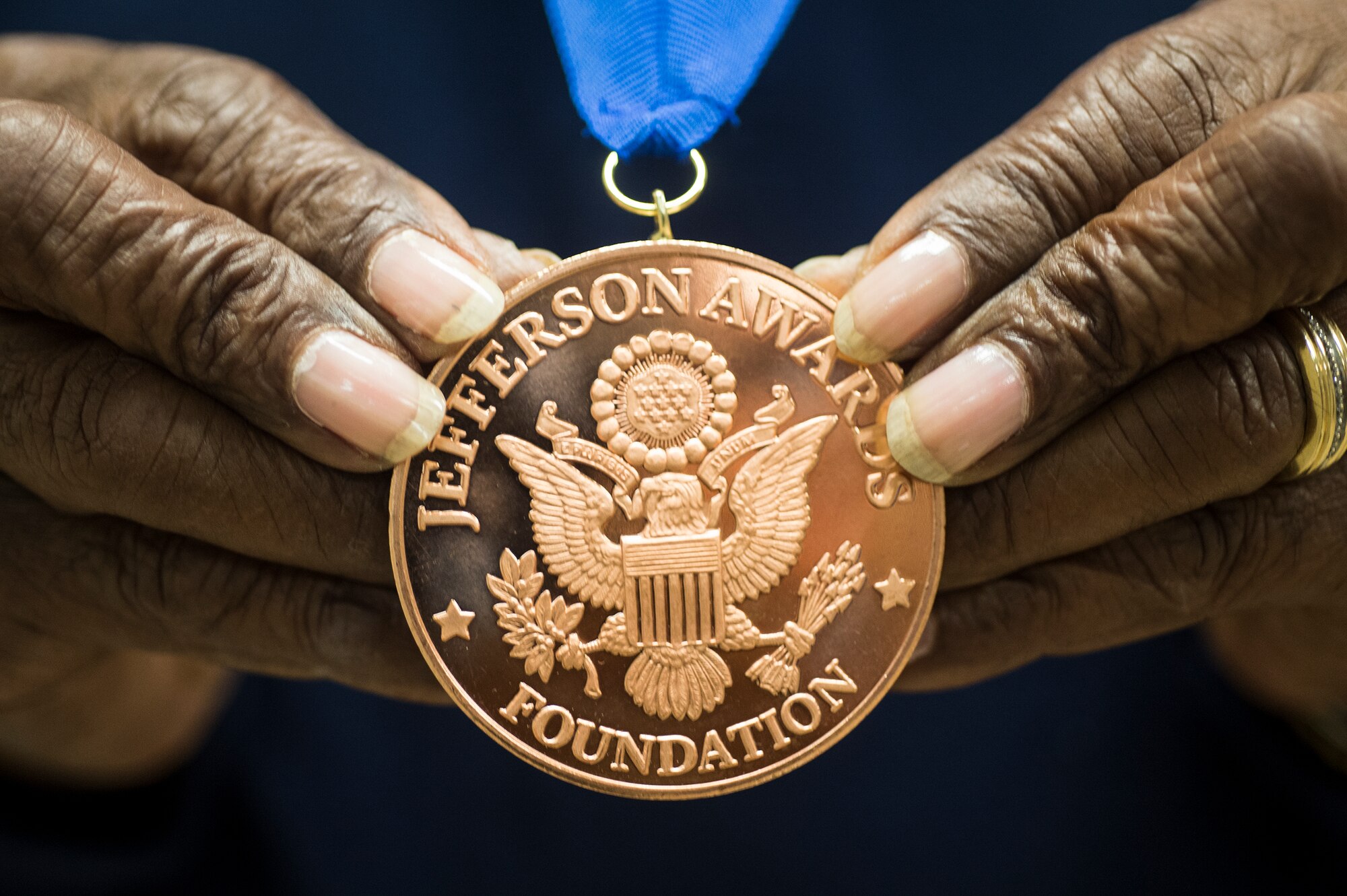 Retired U.S. Air Force Chief Master Sgt. James Ingram, 23d Wing retiree activities office director, grasps his Jefferson Award medal, Jan. 12, 2016, at Moody Air Force Base, Ga. Jacqueline Kennedy Onassis, U.S. Senator Robert Taft, Jr. and Sam Beard founded the Jefferson Award for public service in 1972. (U.S. Air Force photo by Senior Airman Ceaira Tinsley/Released) 