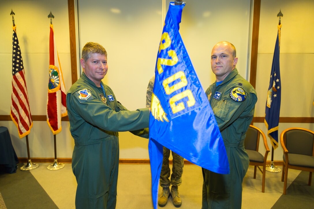 Col. Michael Lesman, the 482nd Operations Group commander, presents the 482nd Operations Support Squadron guidon to Lt. Col. Clint Henderson during an assumption-of-command ceremony at Homestead Air Reserve Base, Florida, in Building 404, Jan. 8. Before taking command of the 482nd OSS, Henderson was the 93rd Fighter Squadron.  (U.S. Air Force photo/Tech. Sgt. Lionel Castellano) 