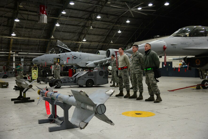 Weapons load crews from the 36th and 25th Aircraft Maintenance Units stand by their respective aircraft prior to the start of the quarterly weapons loading competition on Osan Air Base, Republic of Korea, Jan. 8, 2016. The event added an element of competition to a qualification test for the technicians; competitors complete a written test and a practical demonstration of skill within a fixed amount of time to maintain mission-readiness status. (U.S. Air Force photo/Staff Sgt. Amber Grimm/released)