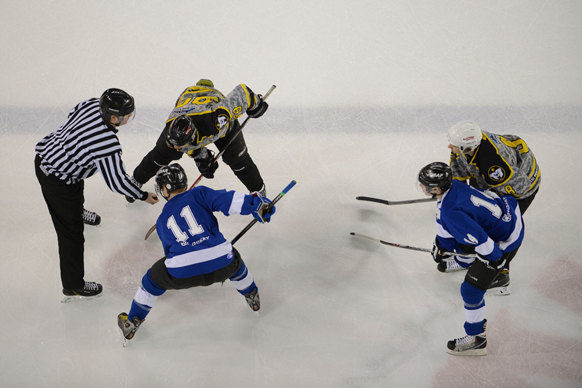 Joint Base Elmendorf-Richardson service members face off for the puck during the 2015 Army vs. Air Force hockey game at the Sullivan Arena, Anchorage, Alaska, Jan. 9, 2016. The game promoted esprit de corps and was intended to enhance the relationship between JBER and the Anchorage community. (U.S. Air Force photo by Airman Valerie Monroy)